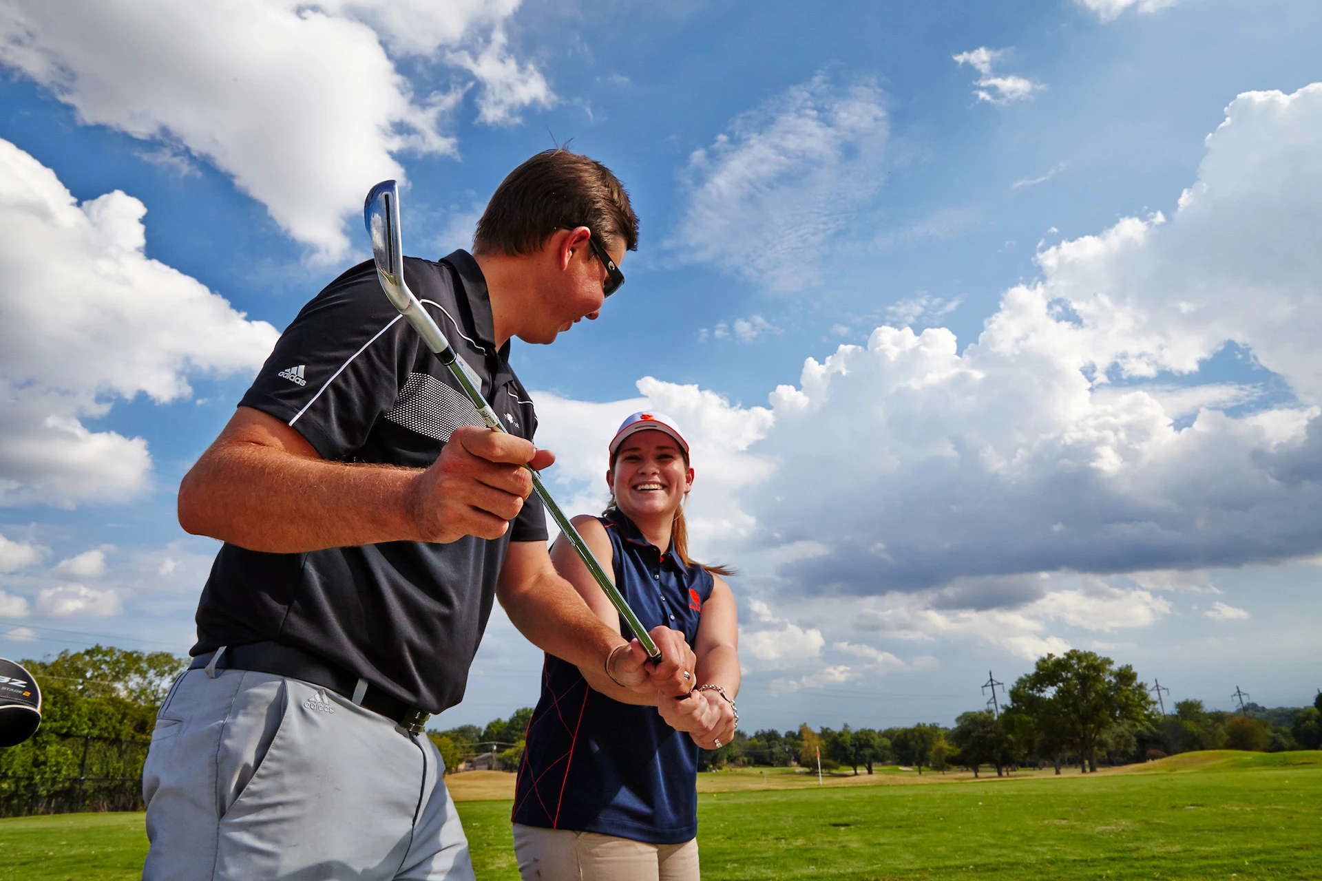 Woman receiving golf lessons