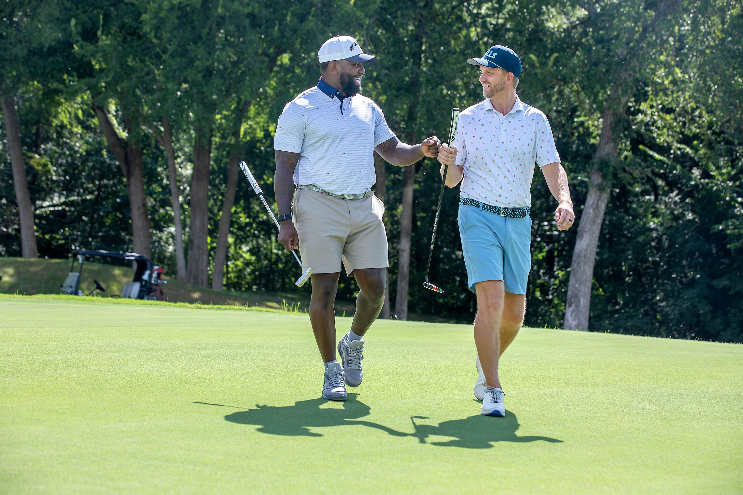 Two men fist bumping playing golf