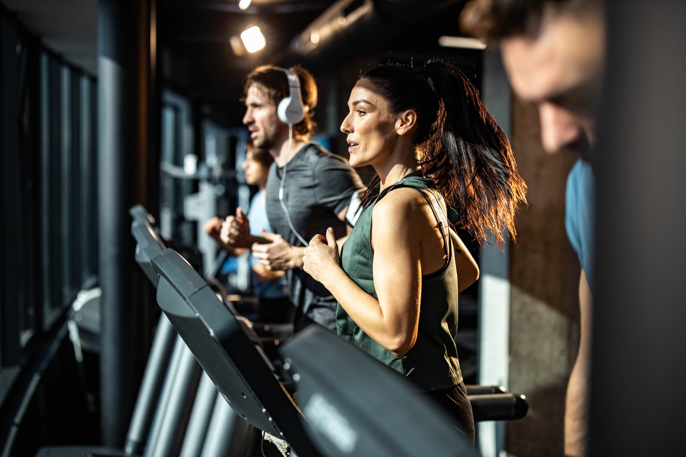 Young men and women running on treadmills