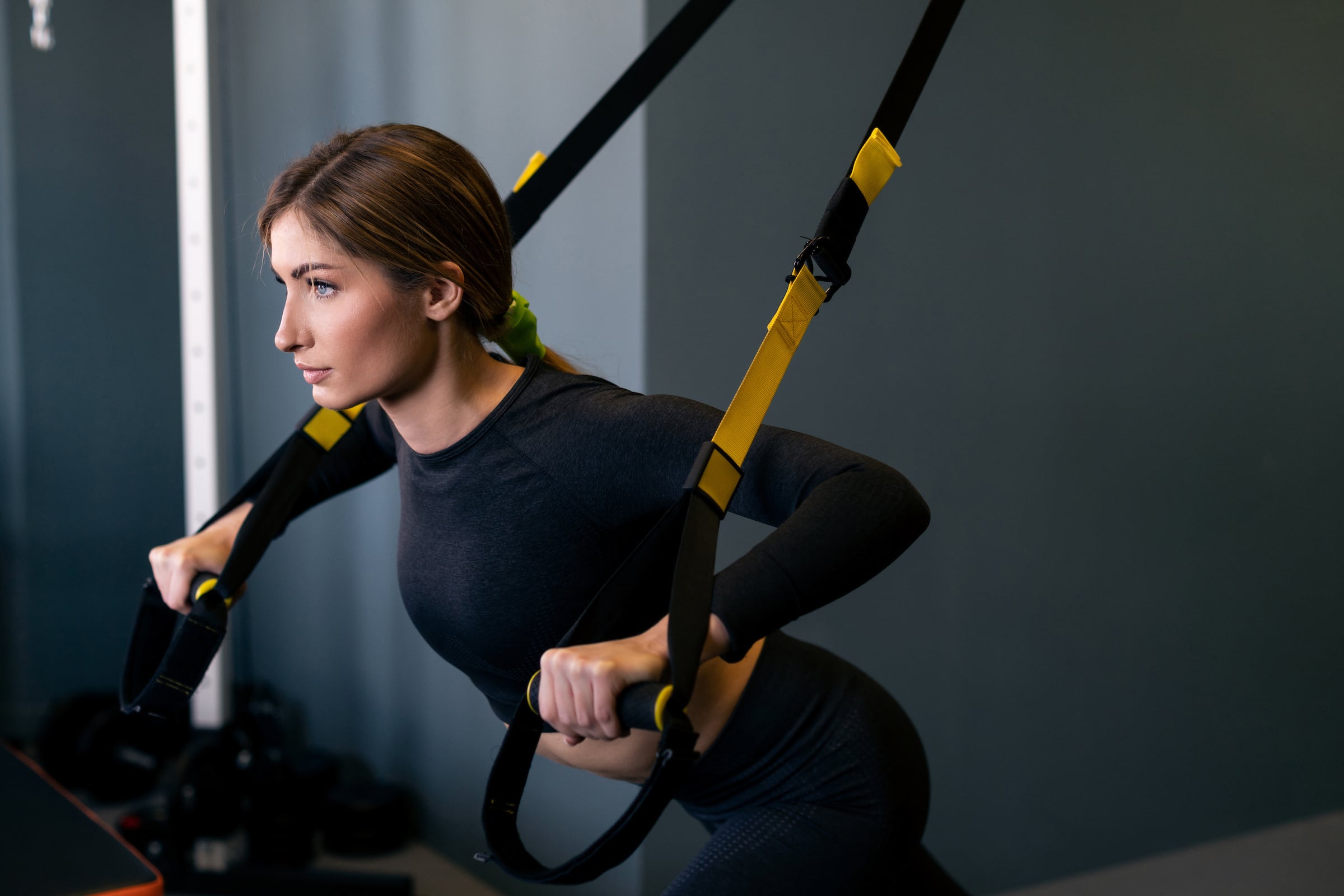 Young lady using TRX bands during a workout session