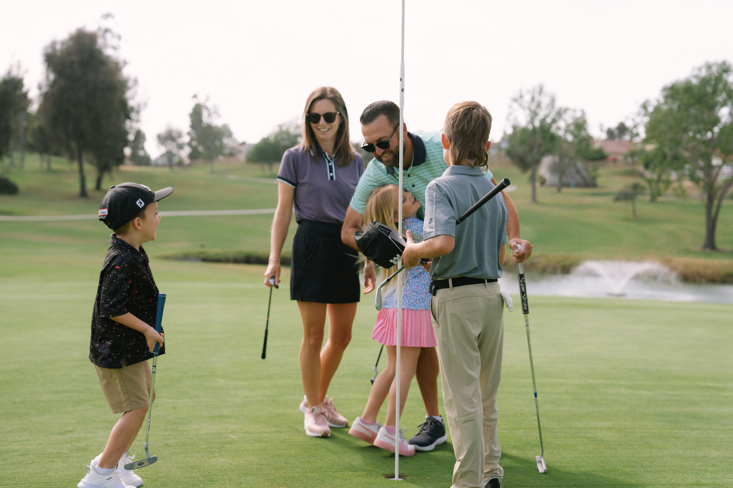 Parents & 3 children celebrating on golf course