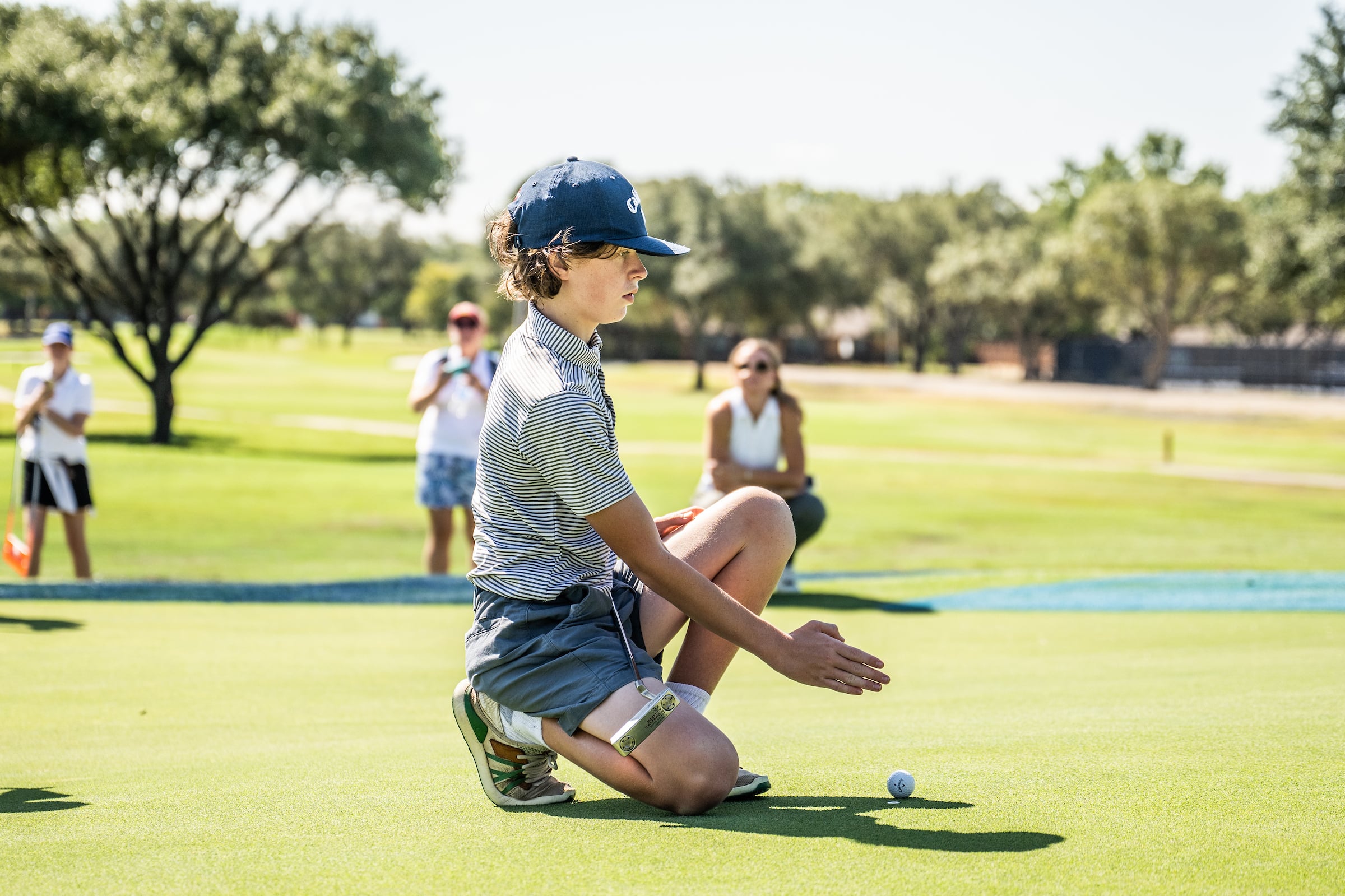 Kid lining golf ball up