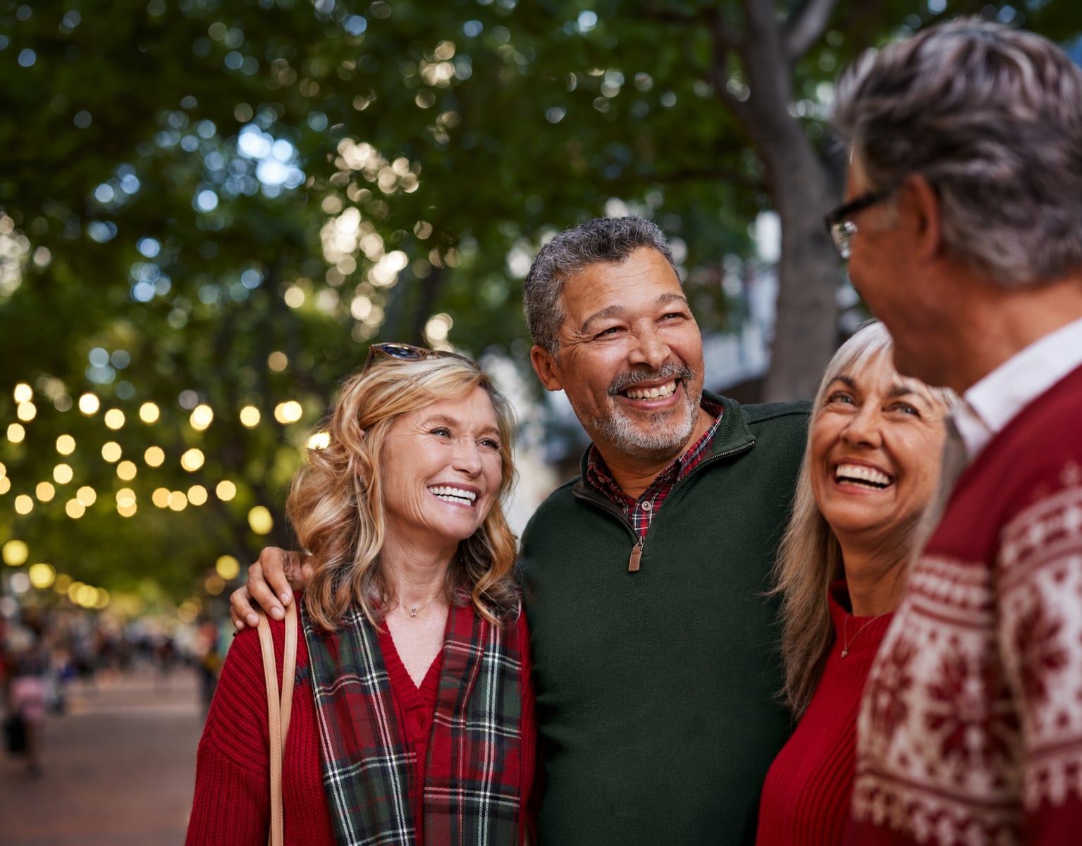 couples laughing wearing festive sweaters