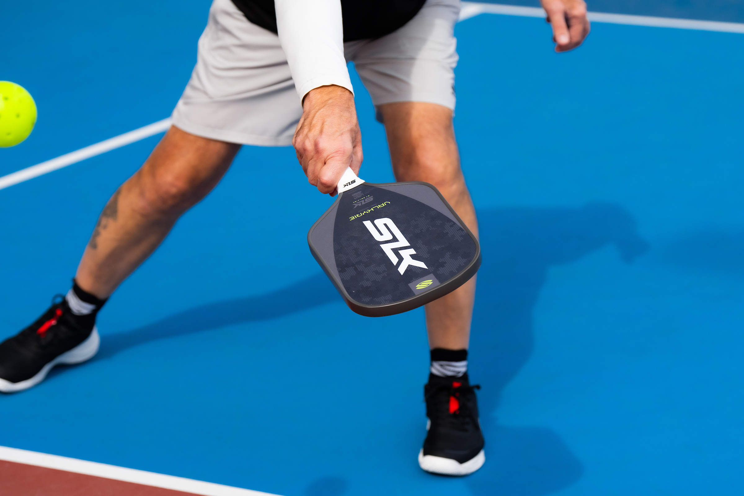 Racquet player on court with pickleball paddle