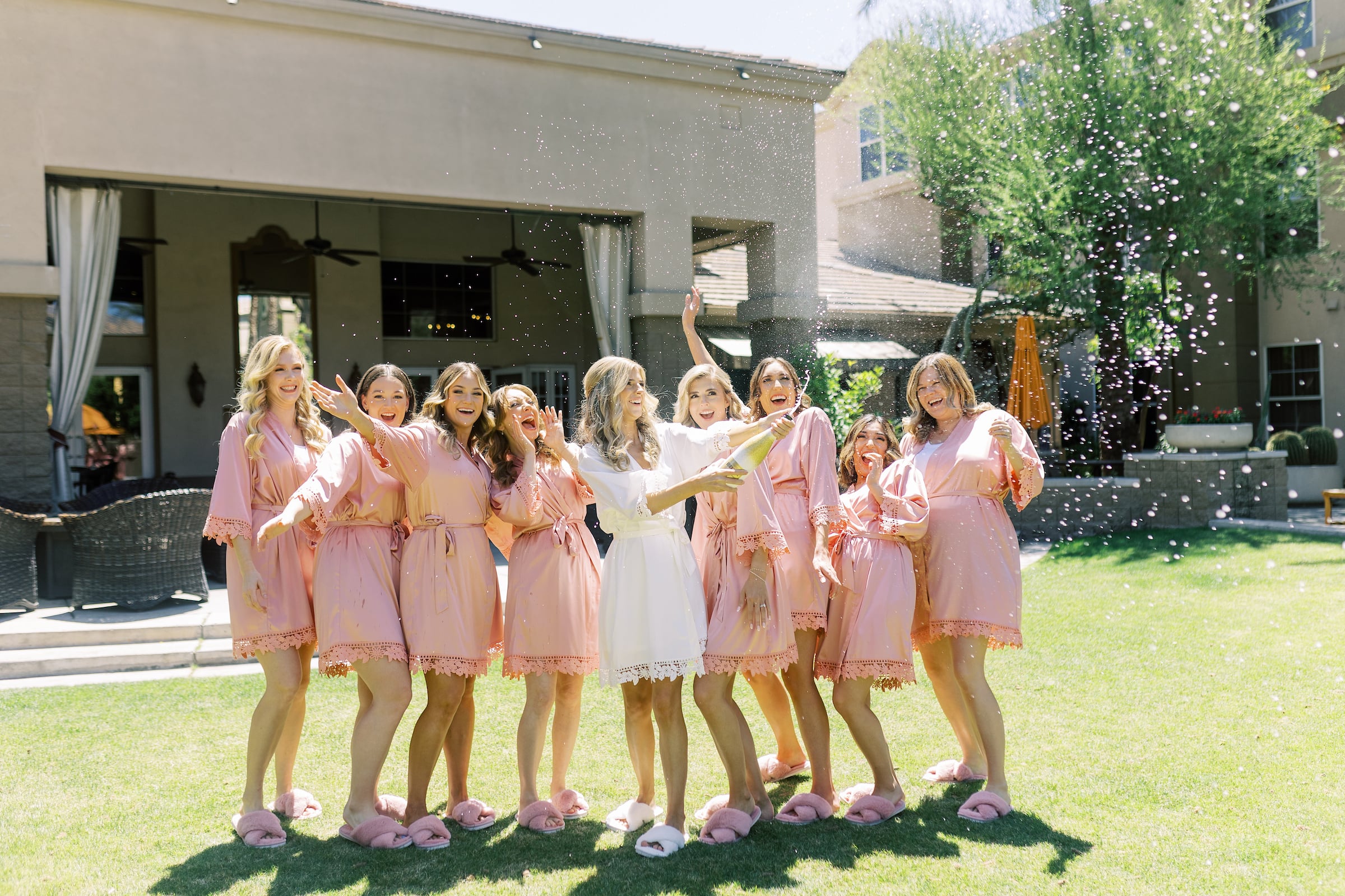 bridesmaids popping champagne