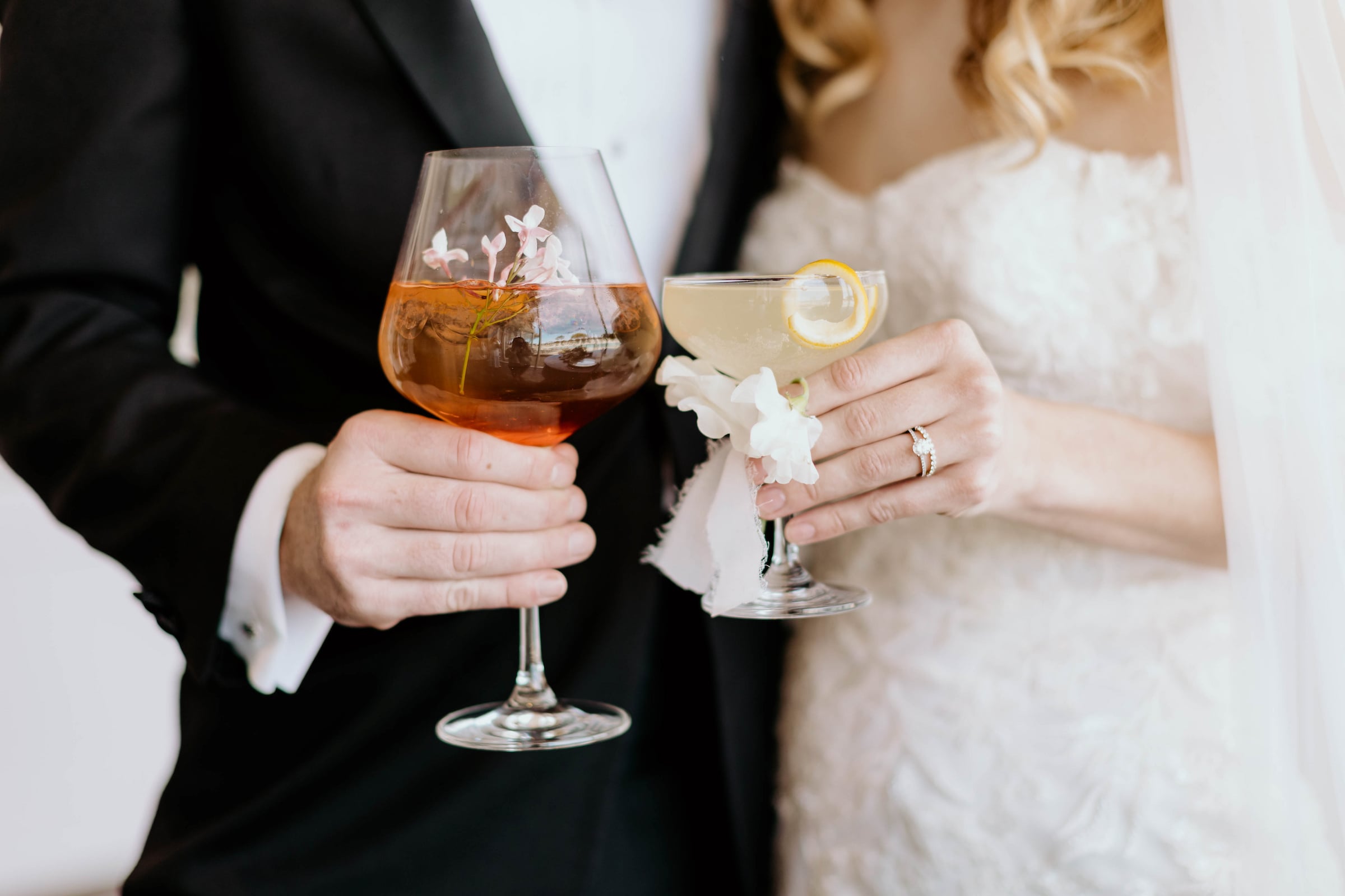 A wedding couple holding a pair of signature drinks