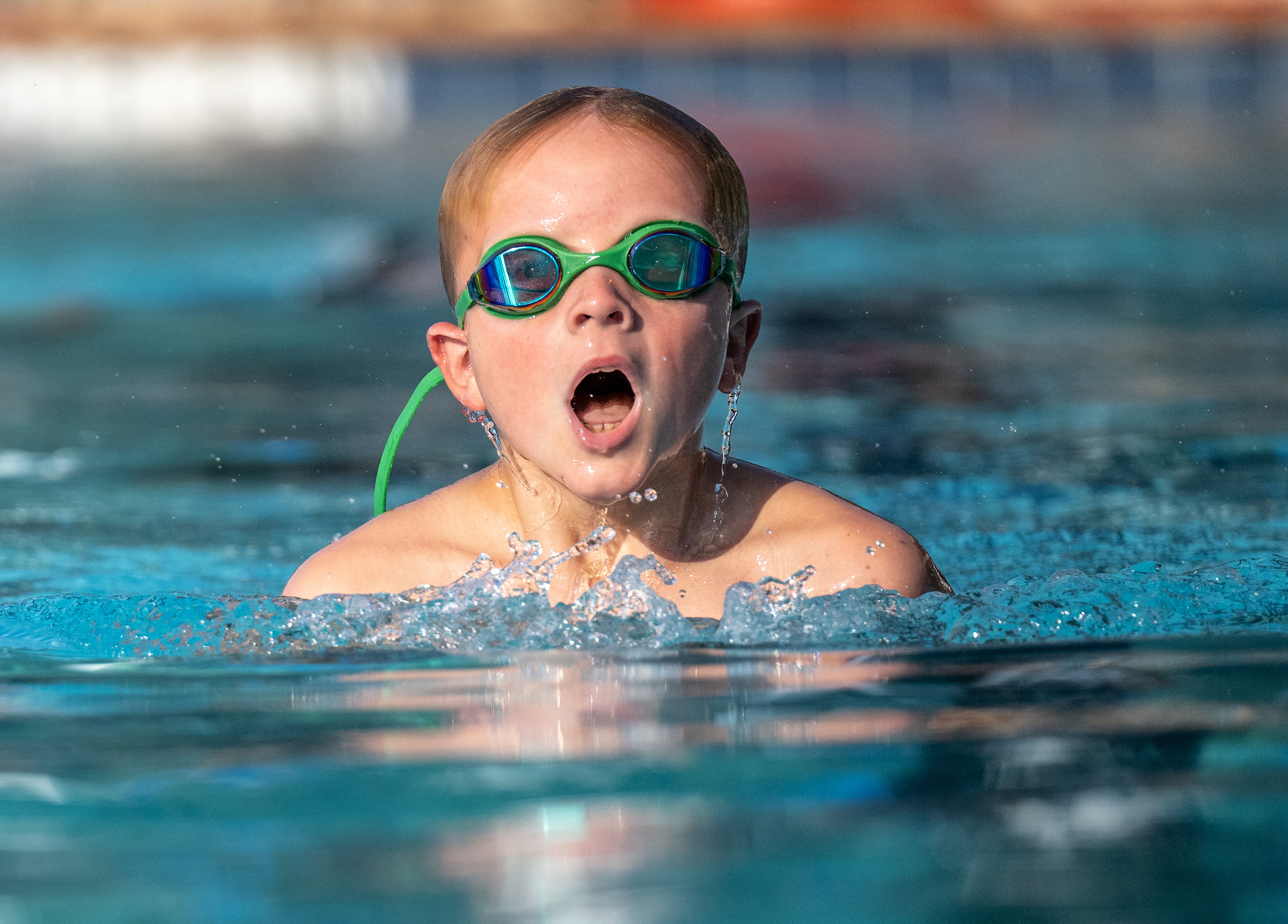 Boy with goggles on swimming