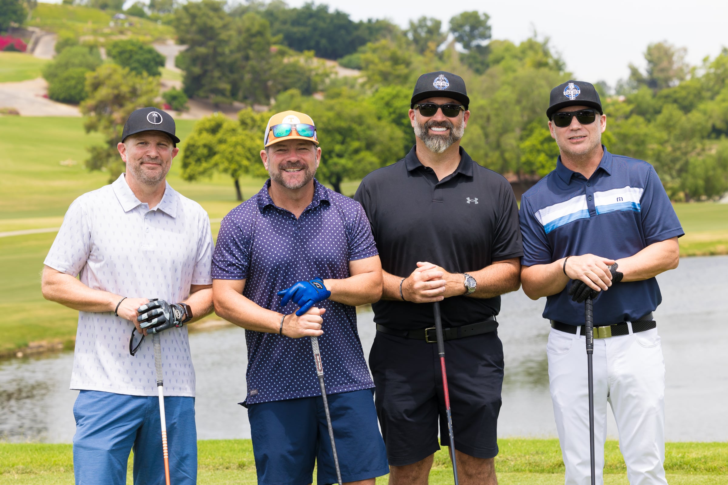 4 men standing on a golf course