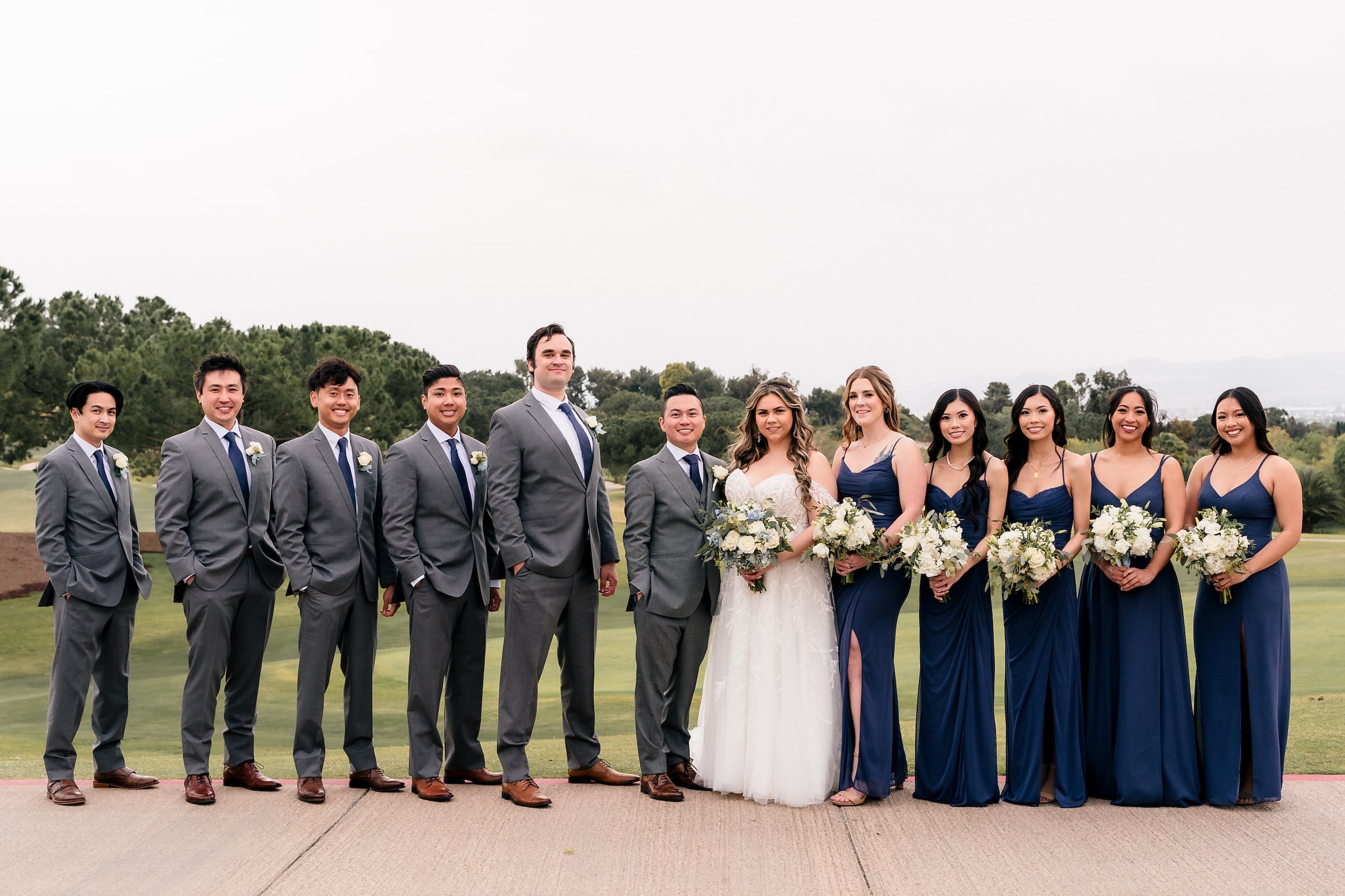 bride and groom standing with wedding party