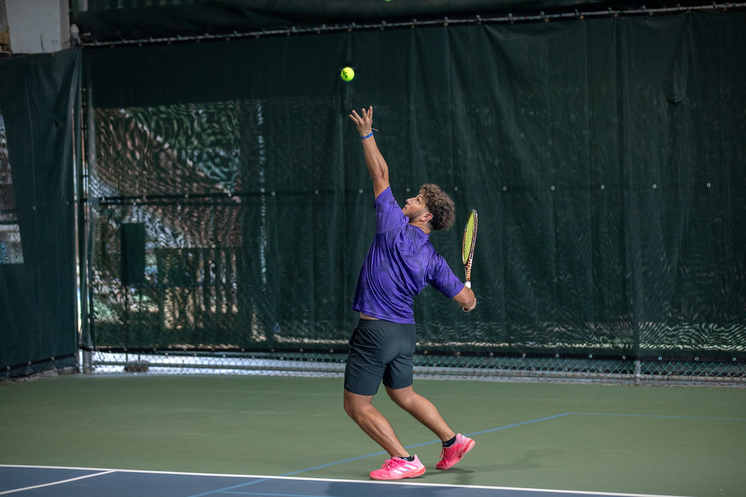 Tennis player serving on court