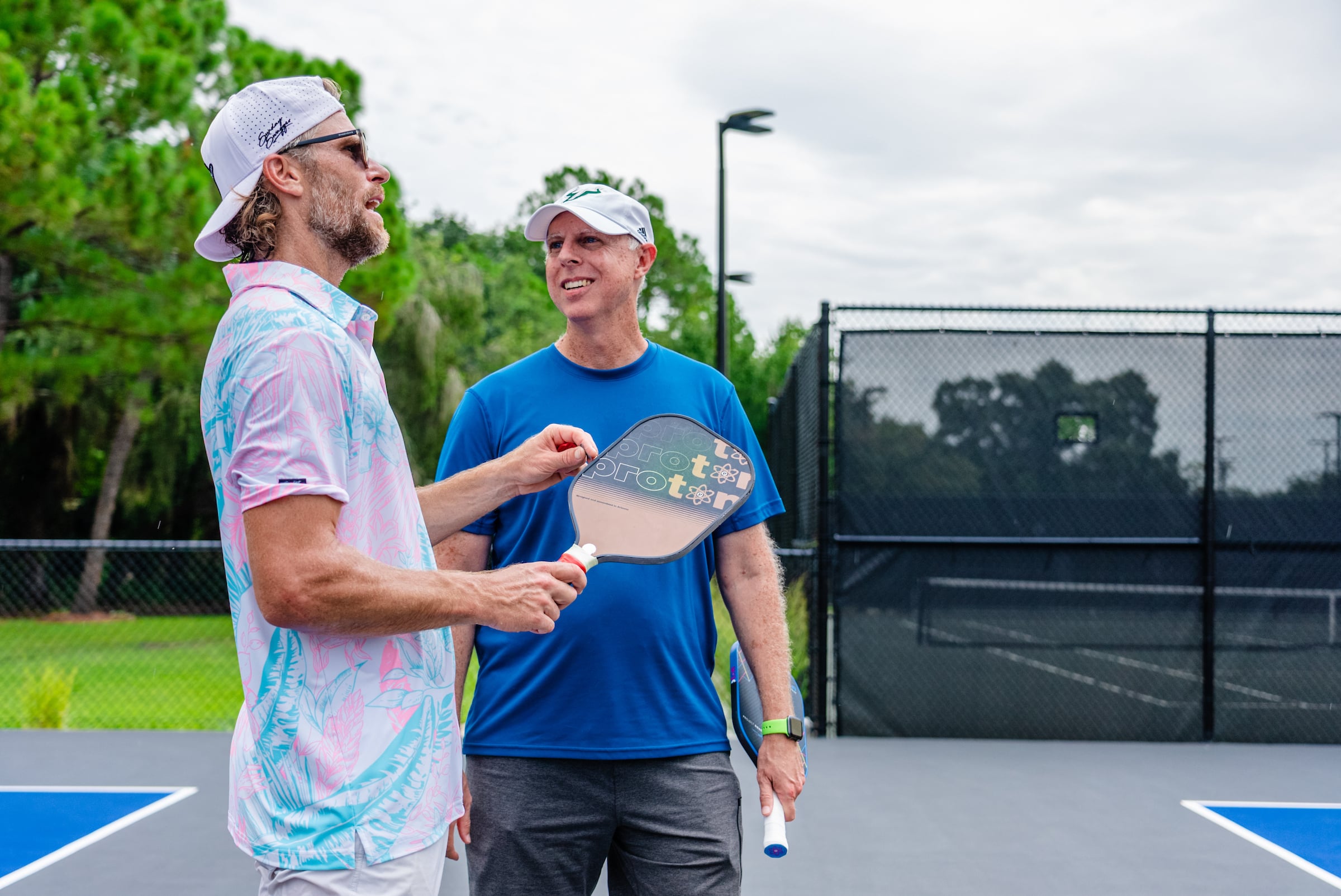 Two men playing tennis smiling