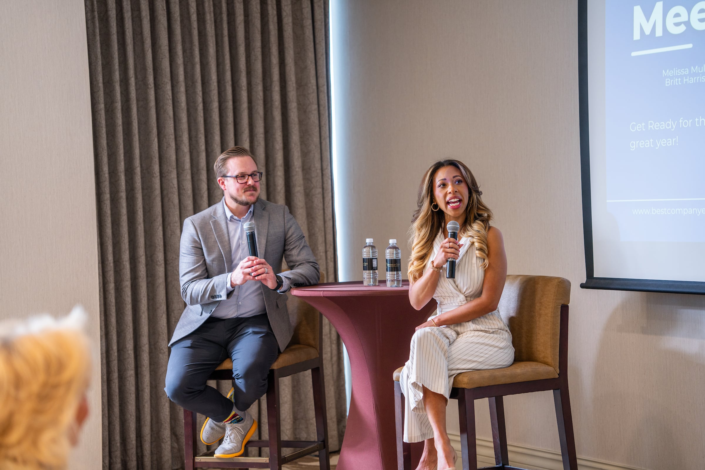 Man & Woman sitting on a stage speaking