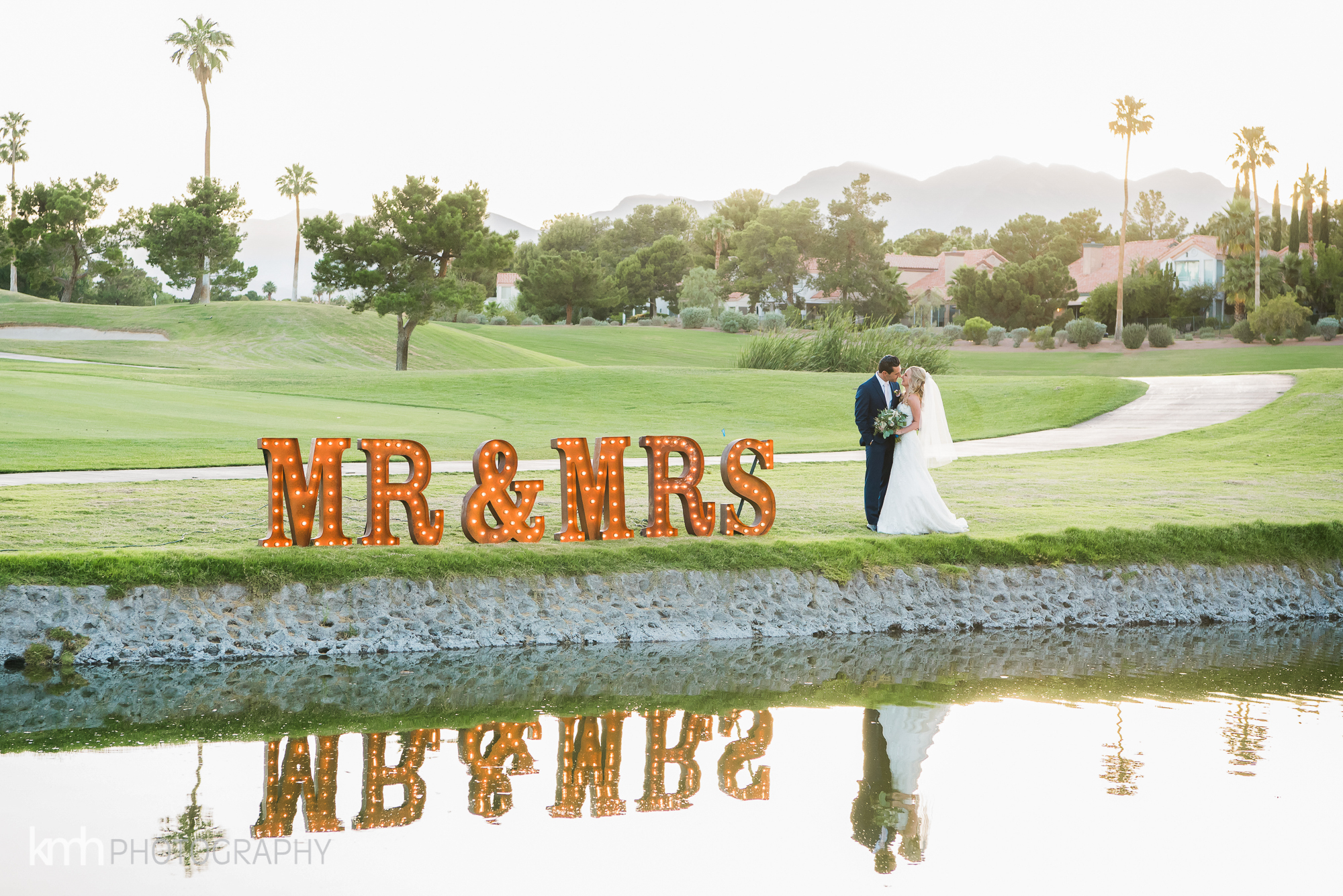 Canyon Gate Country Club - Bride & Groom by water with a large Mr & Mrs sign