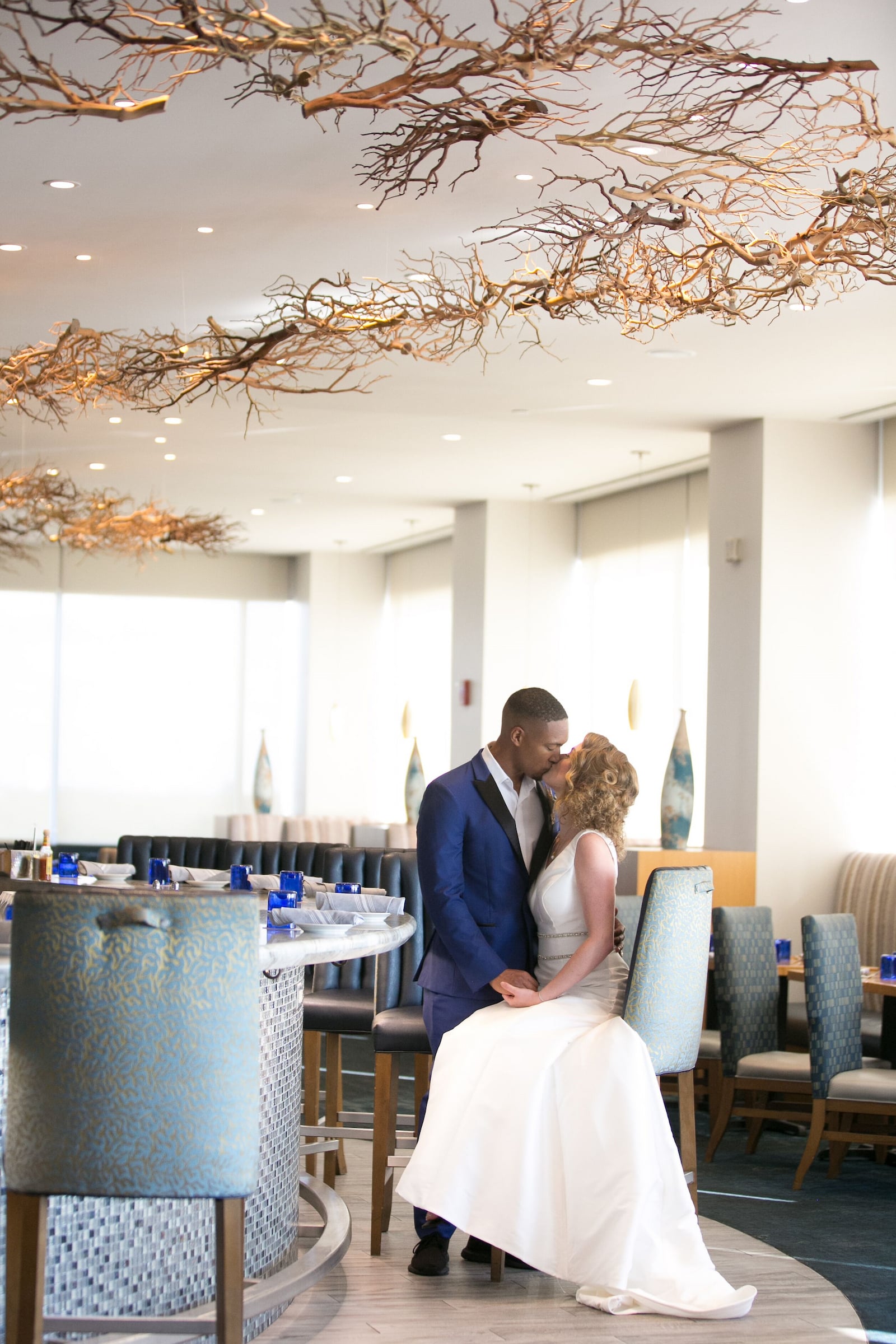 Bride seated with Groom leaning in for a kiss