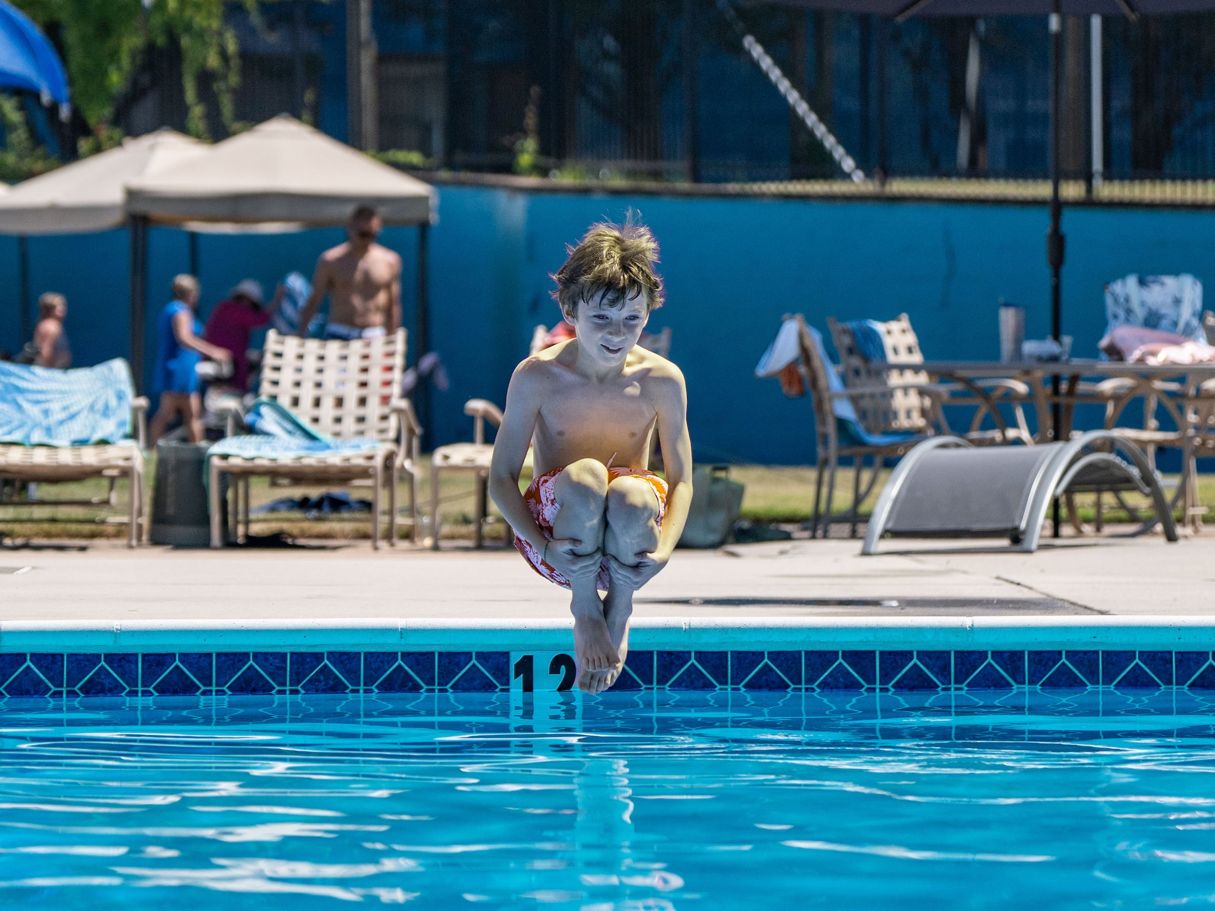 Boy jumping into pool