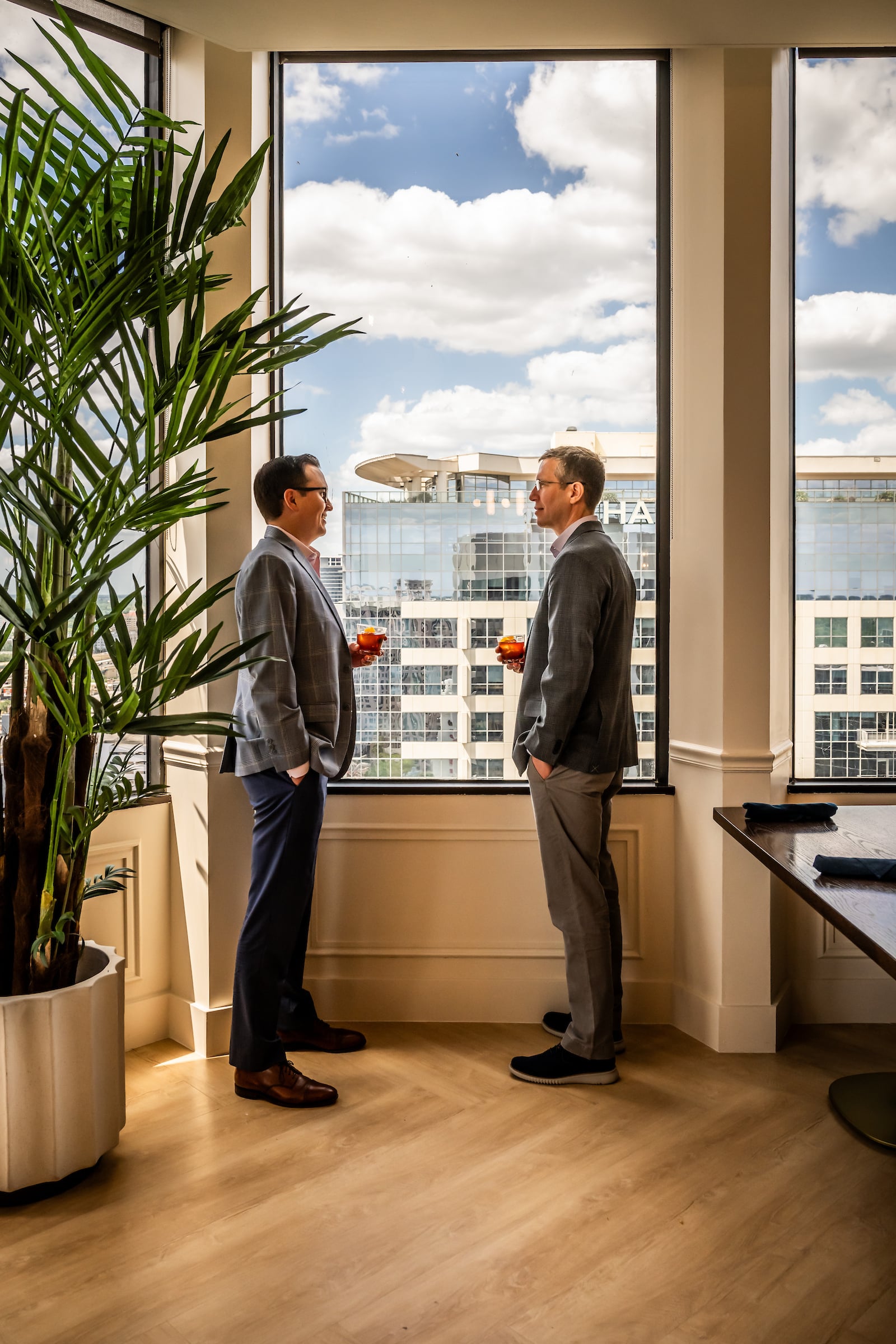 Two men standing in front of a window