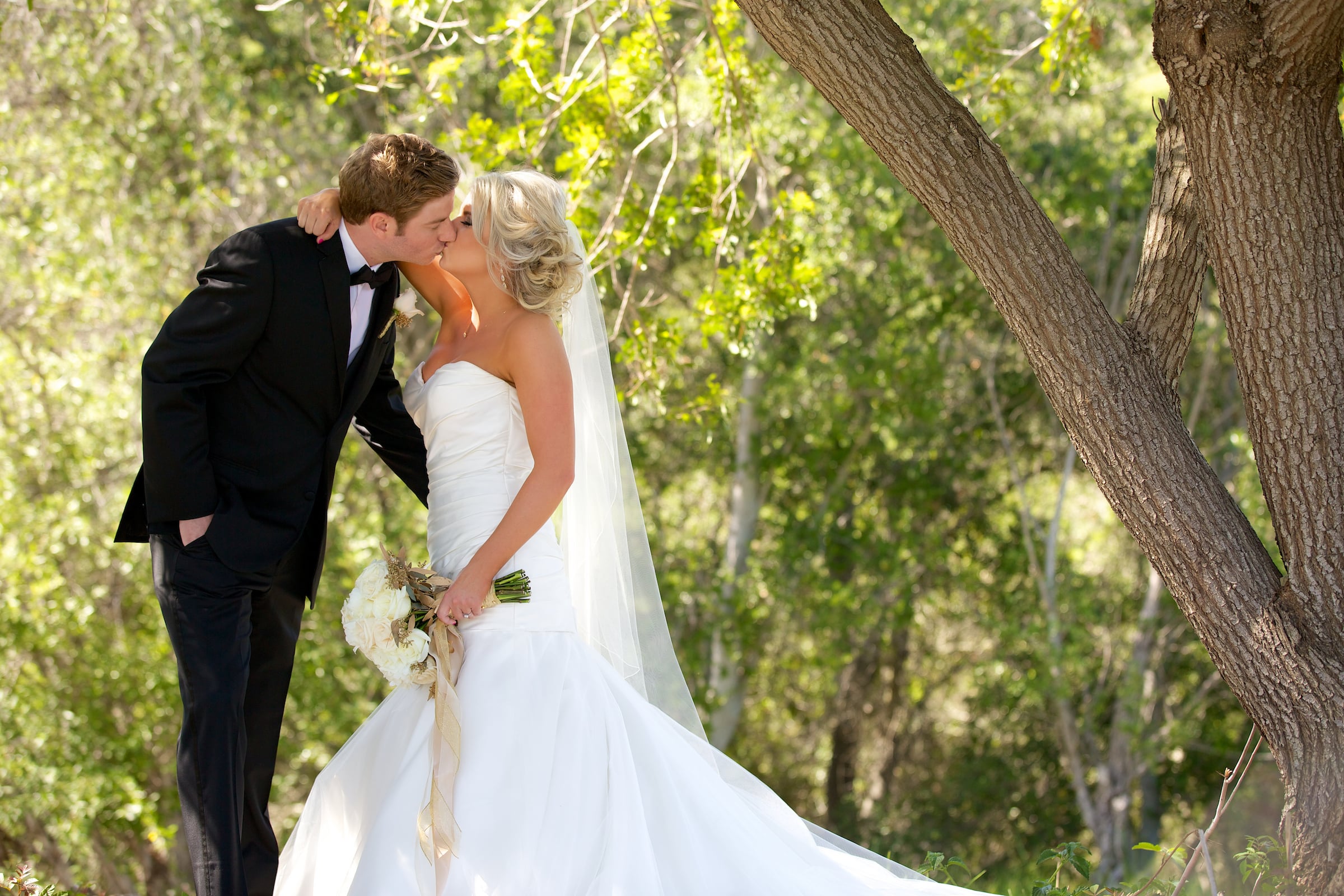 Bride & Groom kissing under a tree on golf course