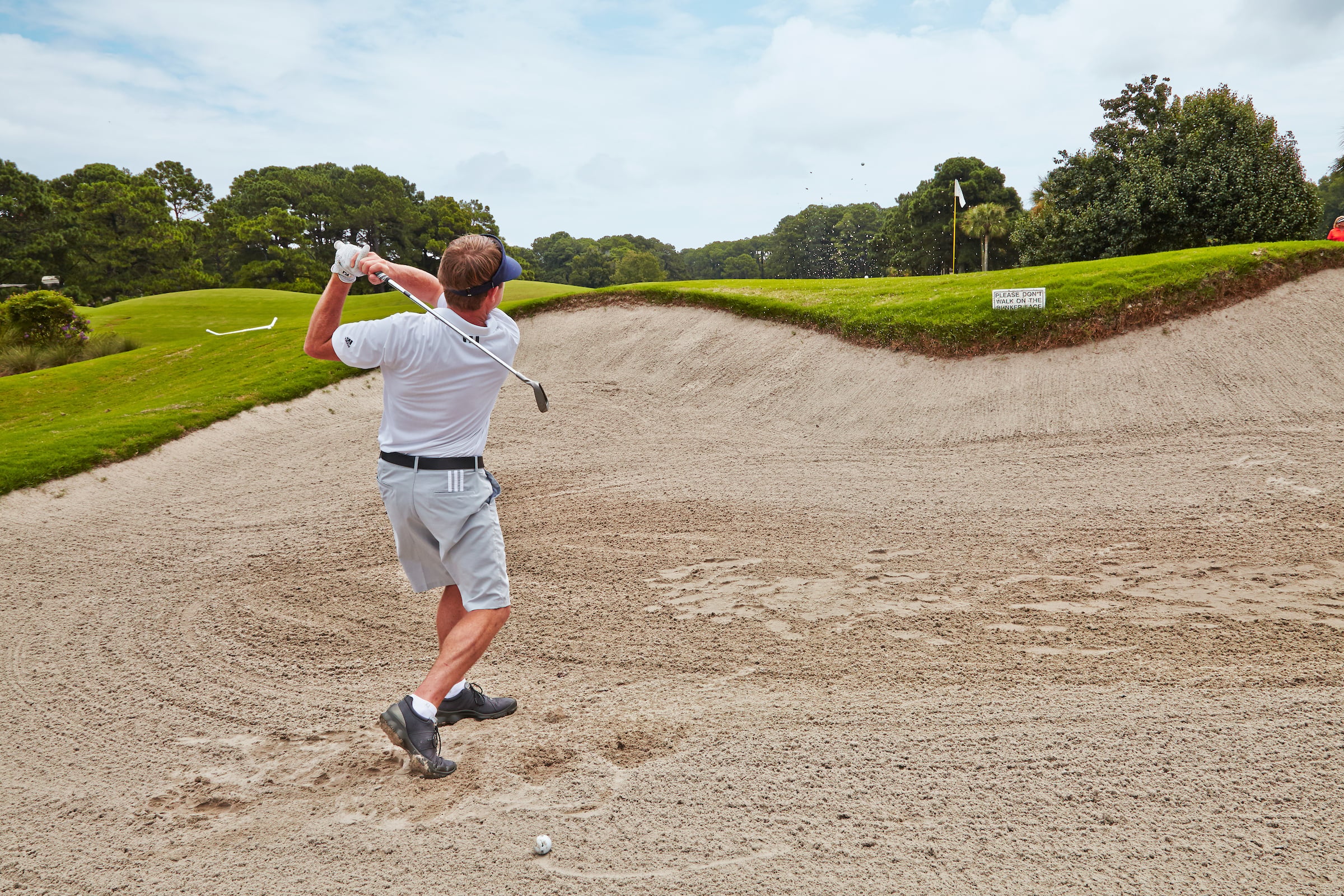 Man playing golf in a bunker