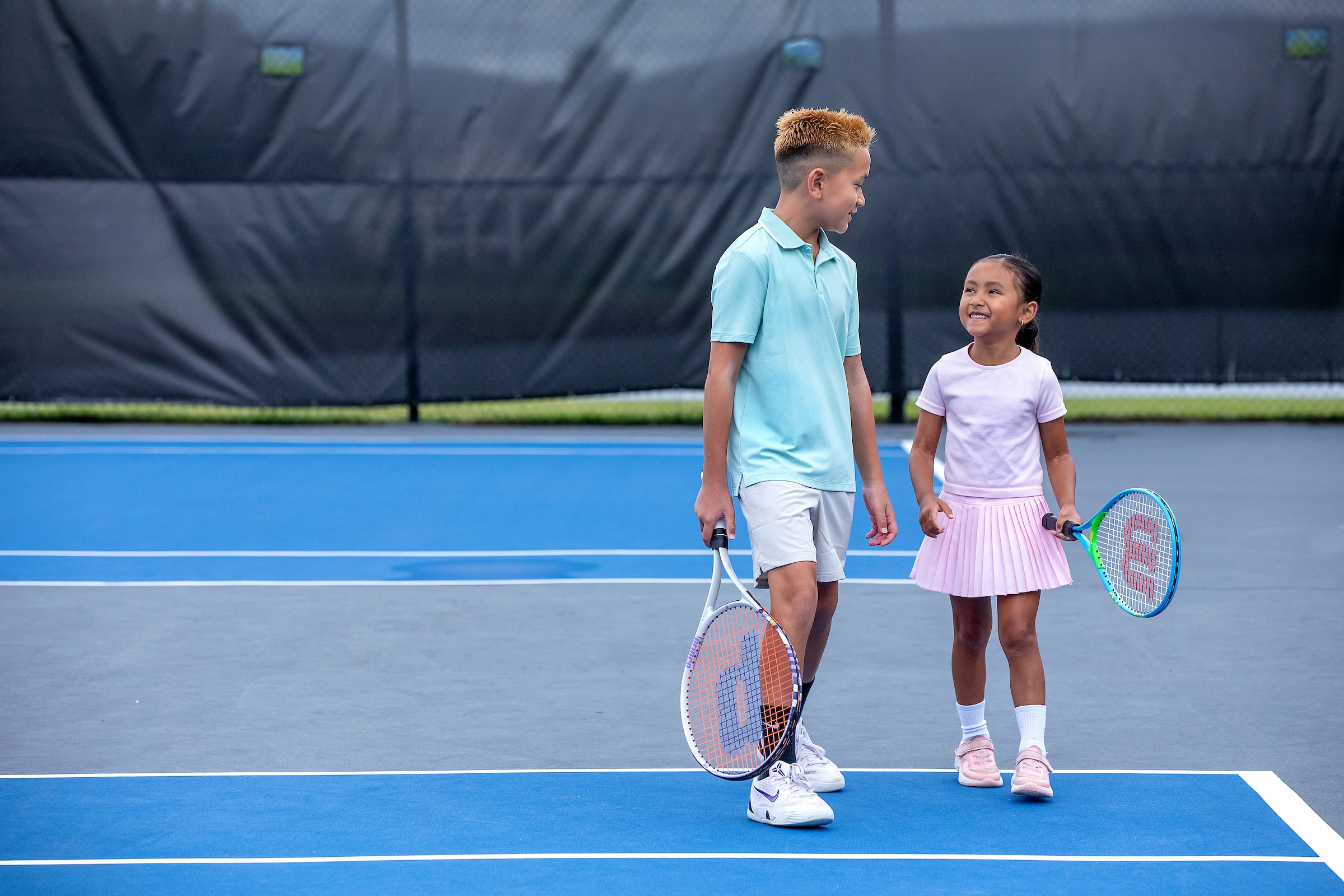 two kids practicing tennis
