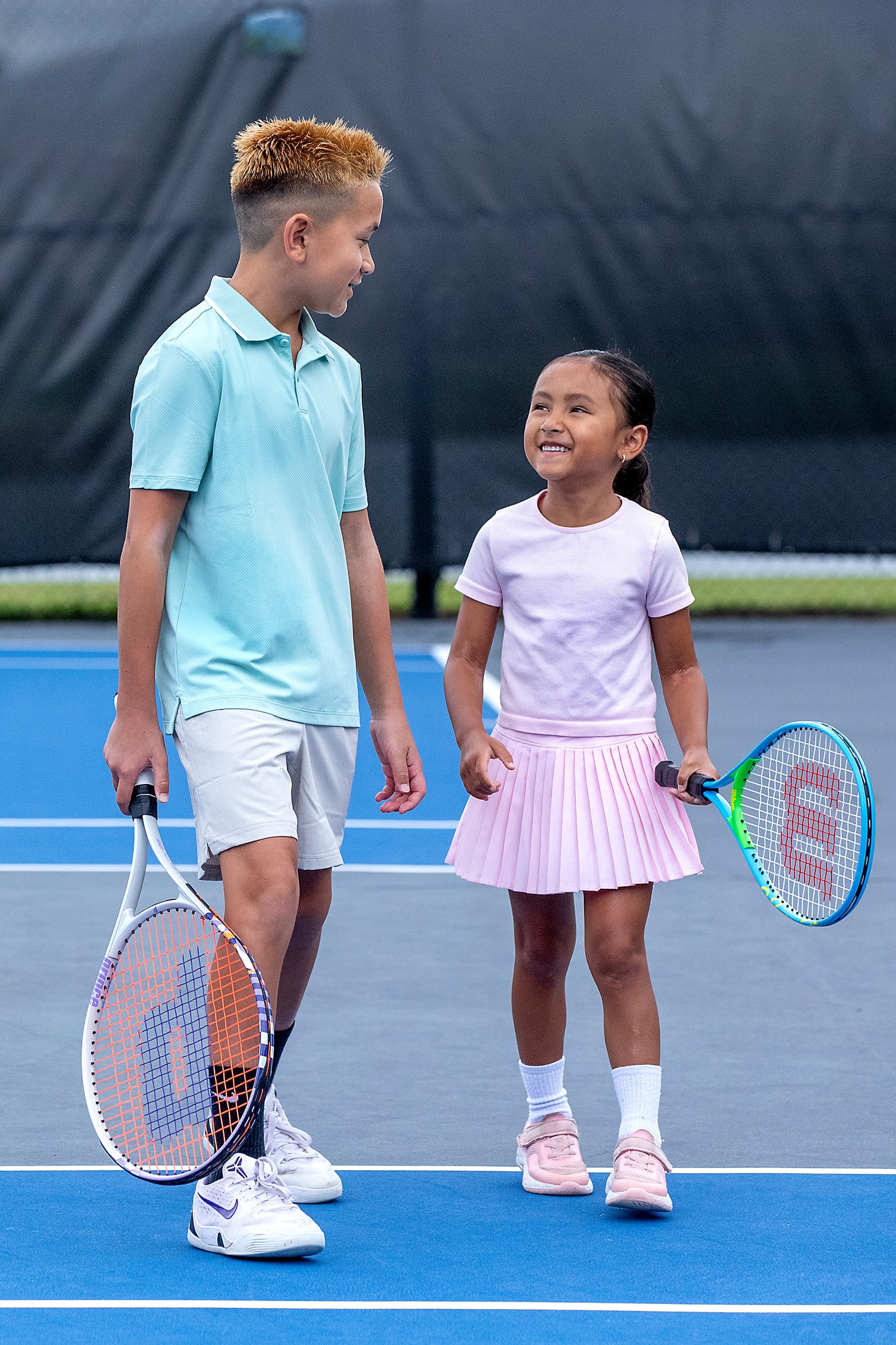 Young boy and girl on the tennis court
