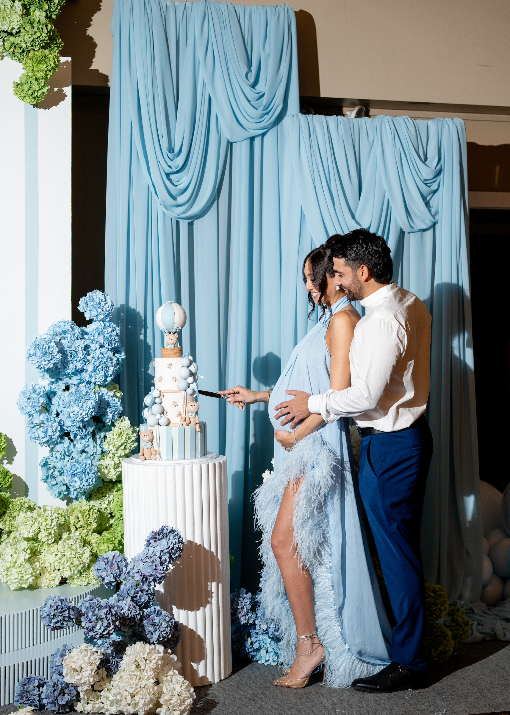 mom and dad cutting cake at a baby shower