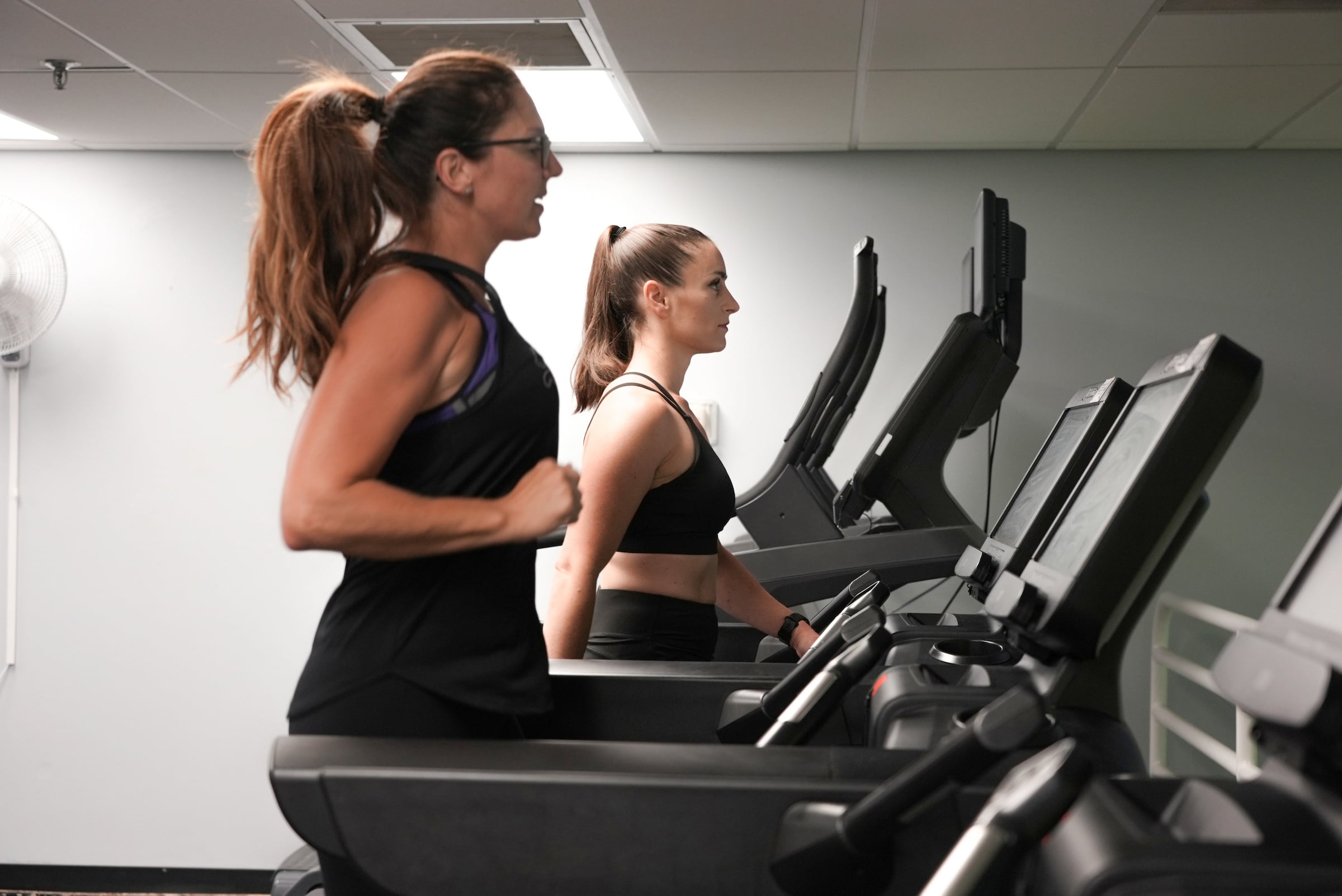 Two women walking on treadmills