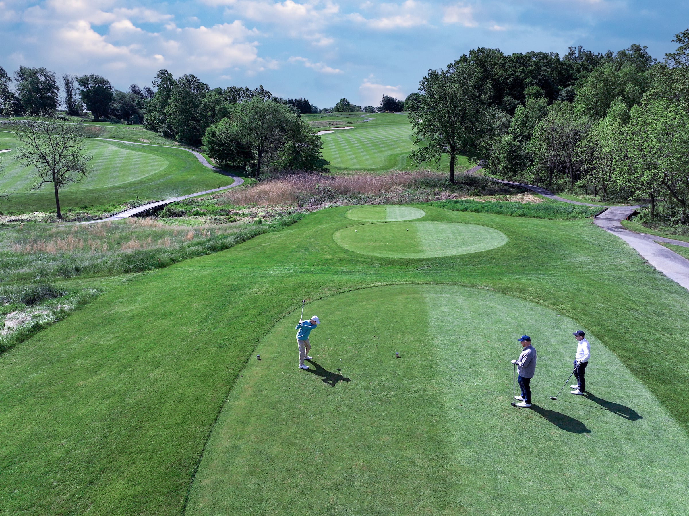 Aerial view of golfer hitting a golf ball.