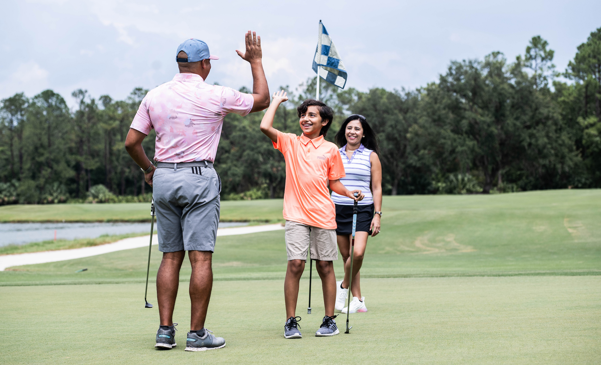 young members high fiving while playing golf