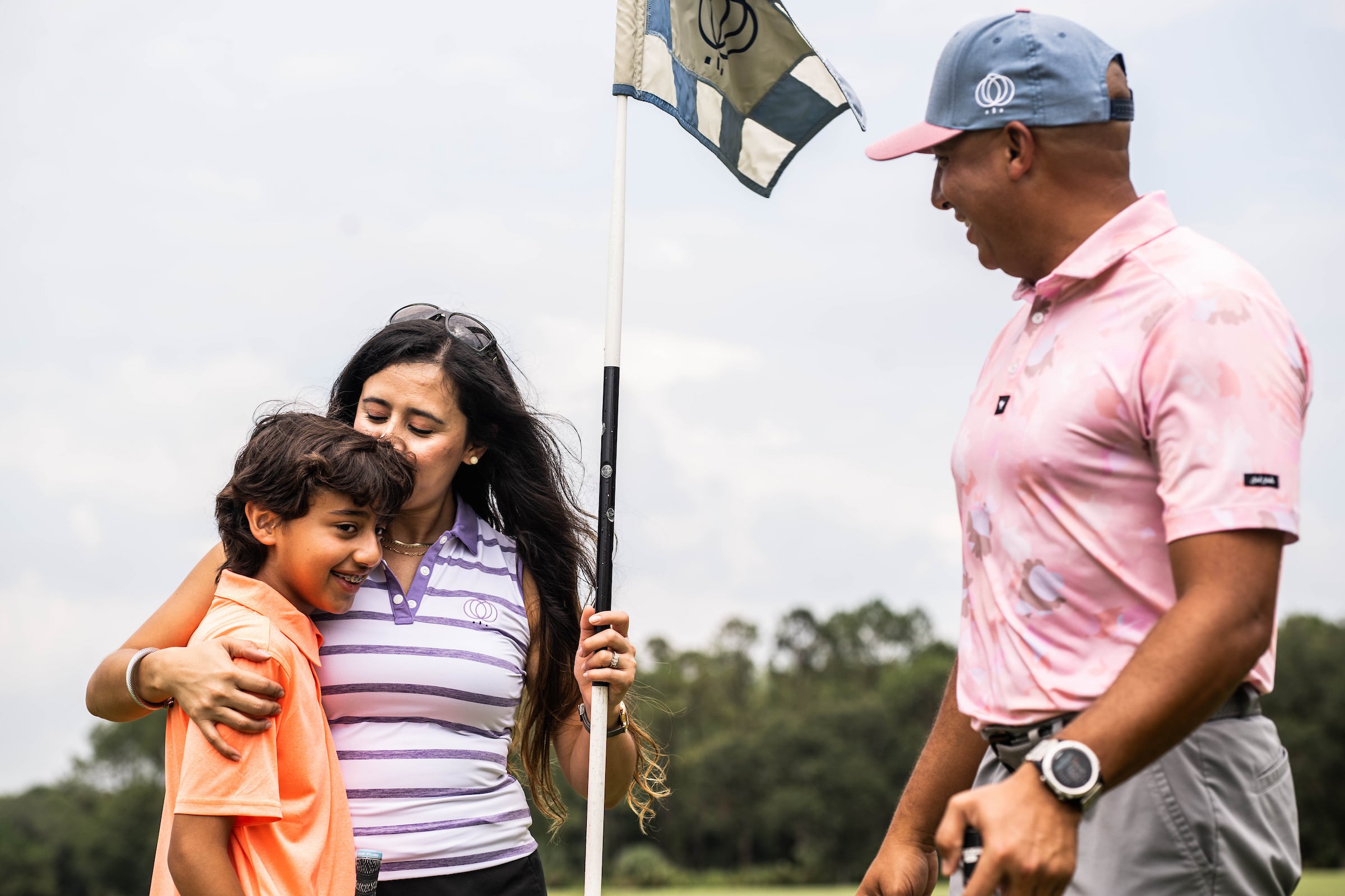Mother embracing child playing golf