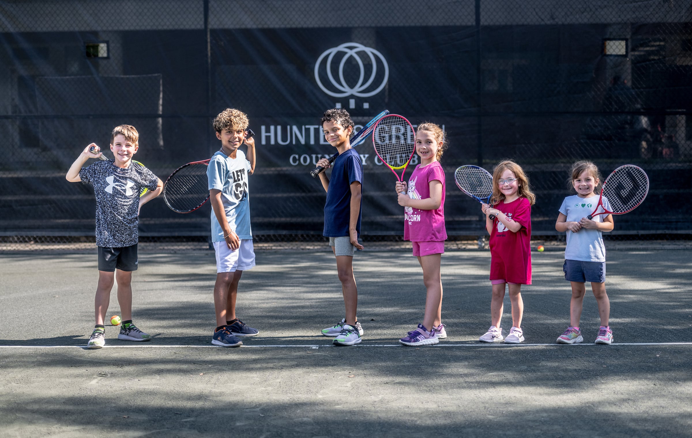 Group of six children playing tennis