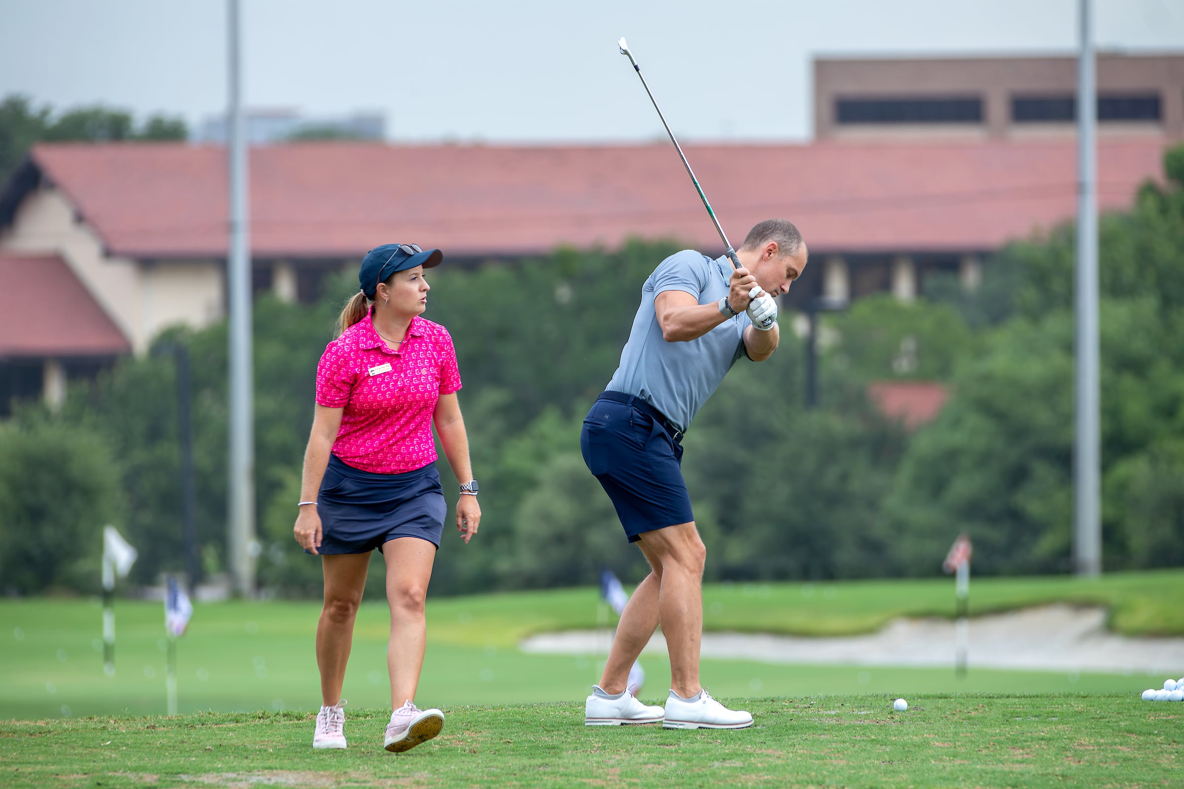 female golf instructor with male student