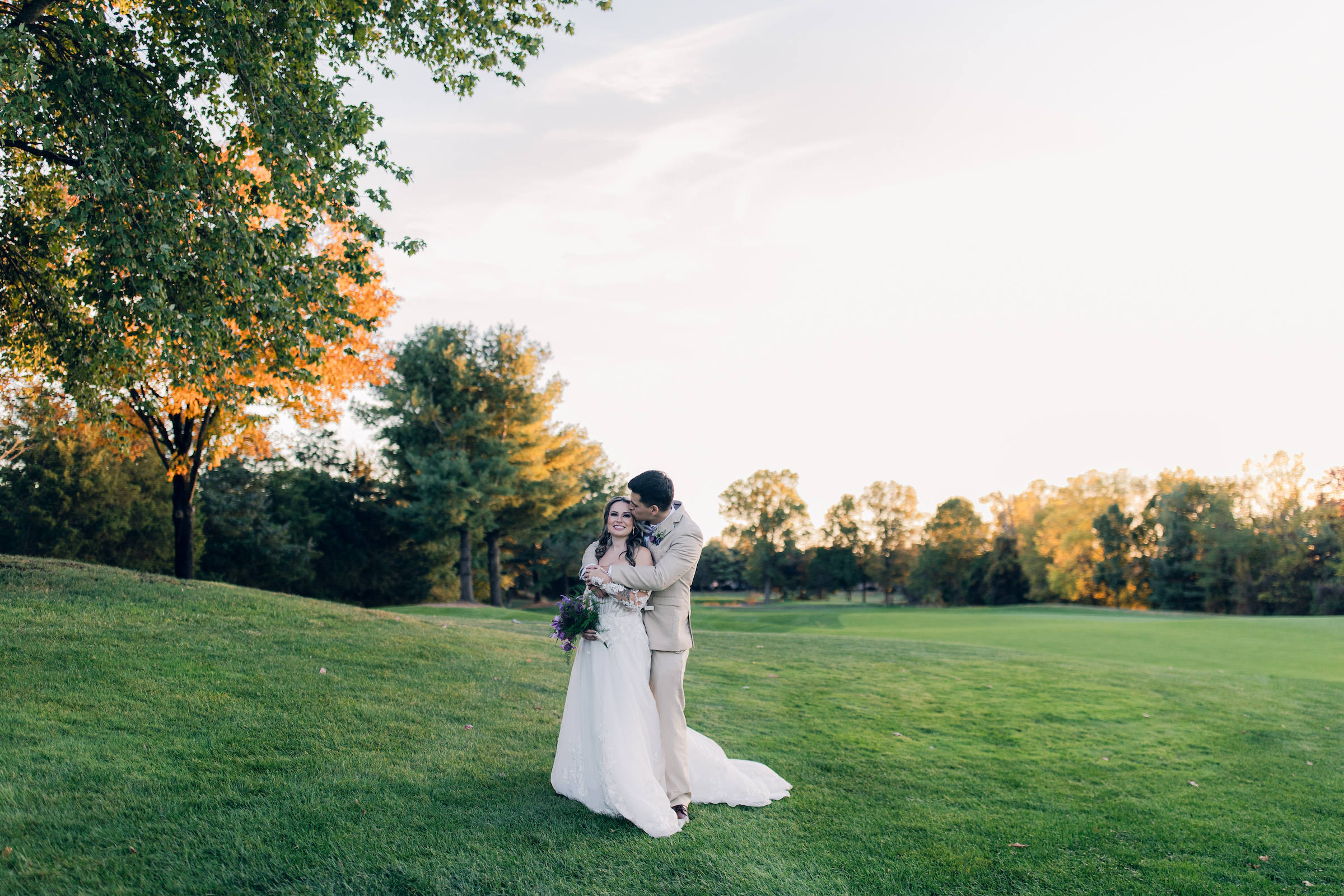 bride and groom taking photos on the golf course