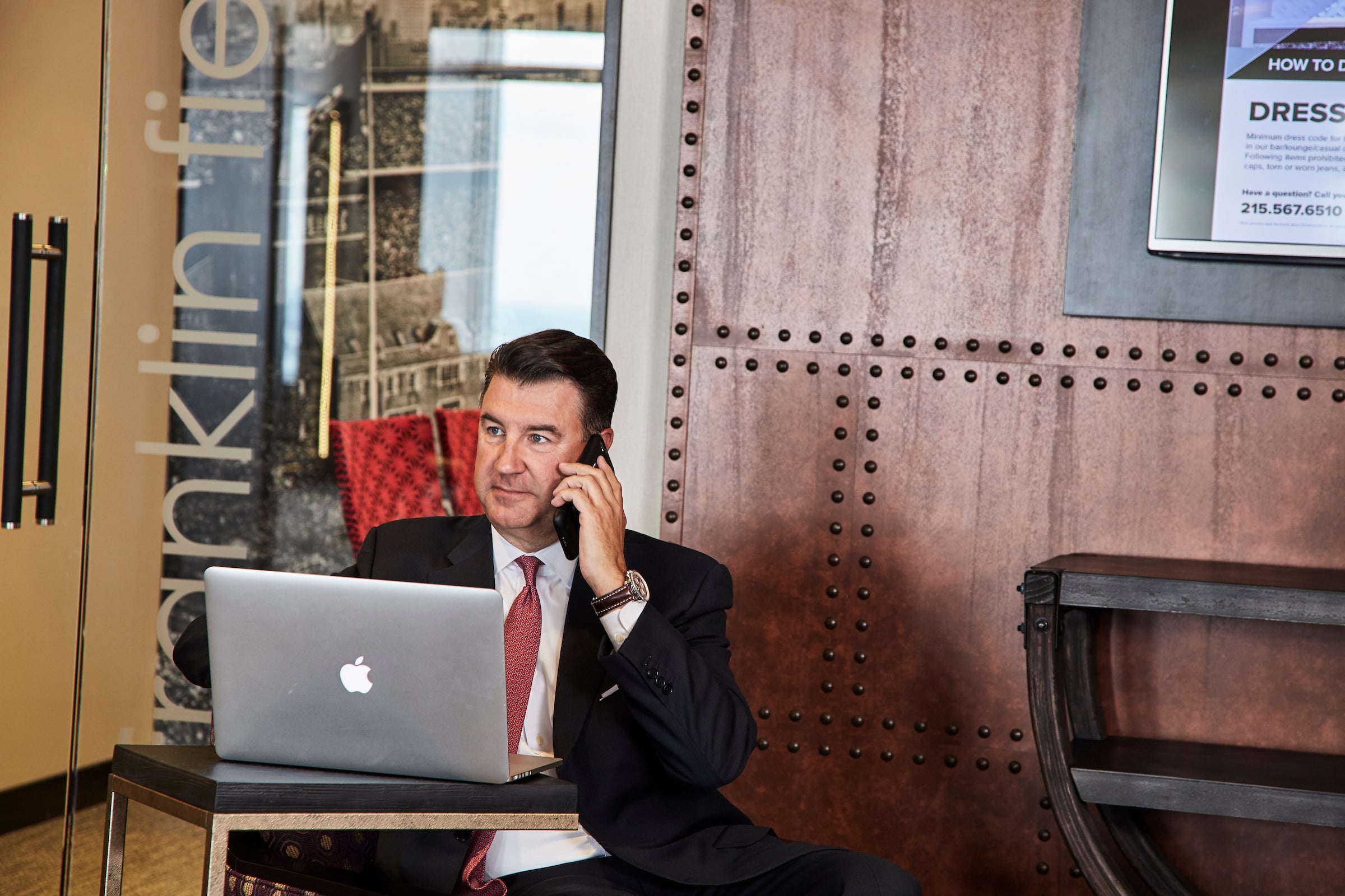 Man sitting in Pyramid Club lobby working on a computer