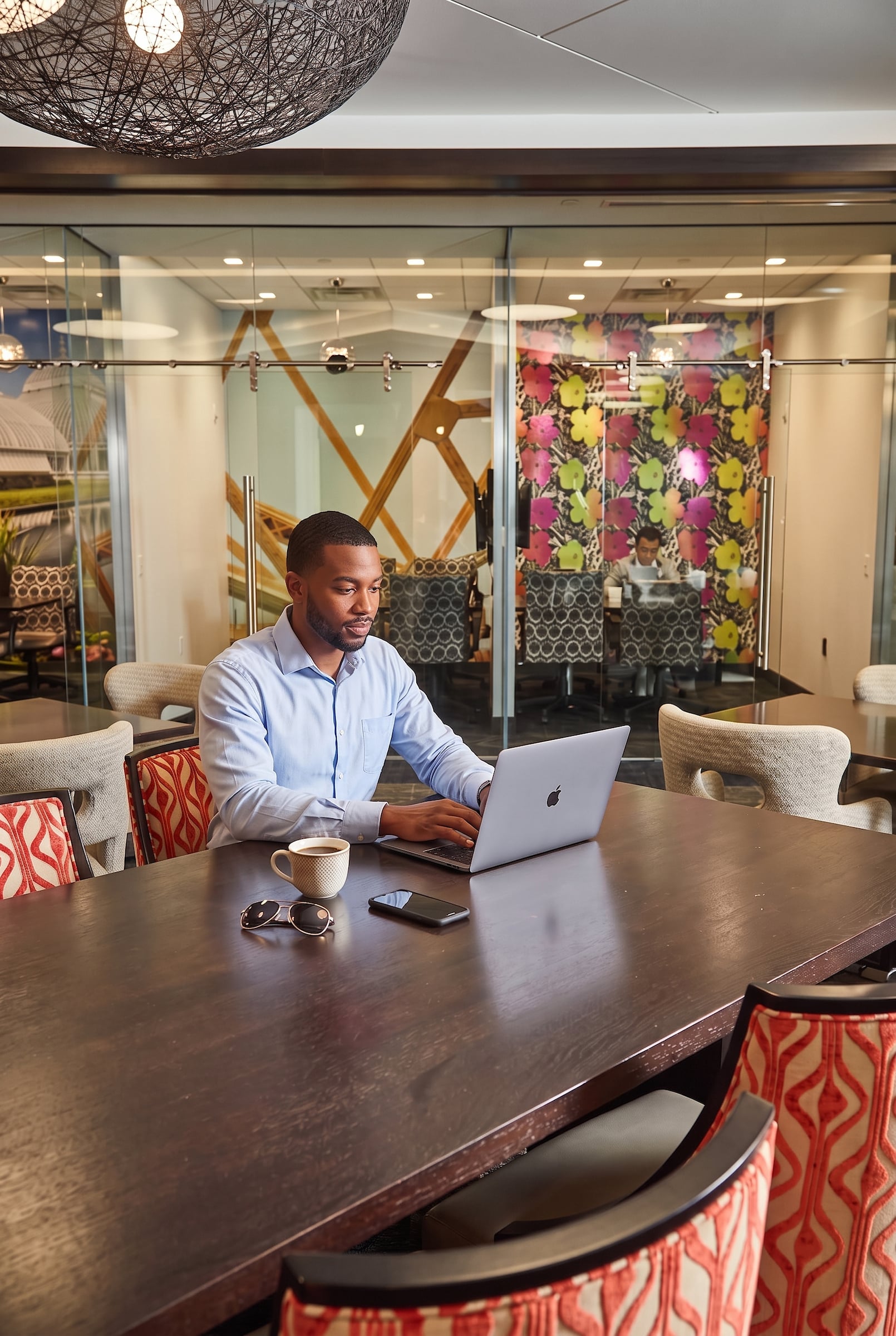 Man seated at a table with a computer open at Rivers Club