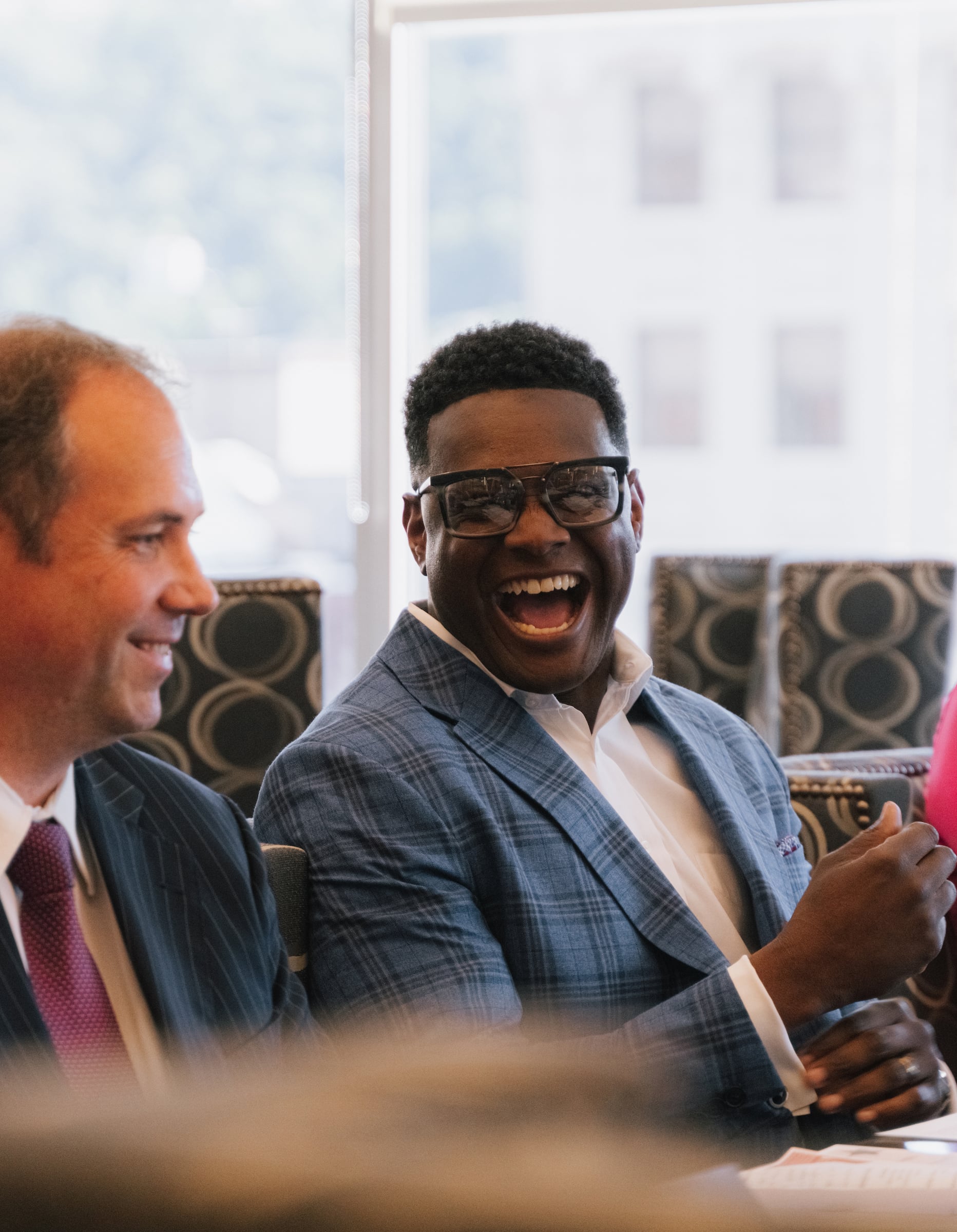 two men in a meeting smiling & laughing