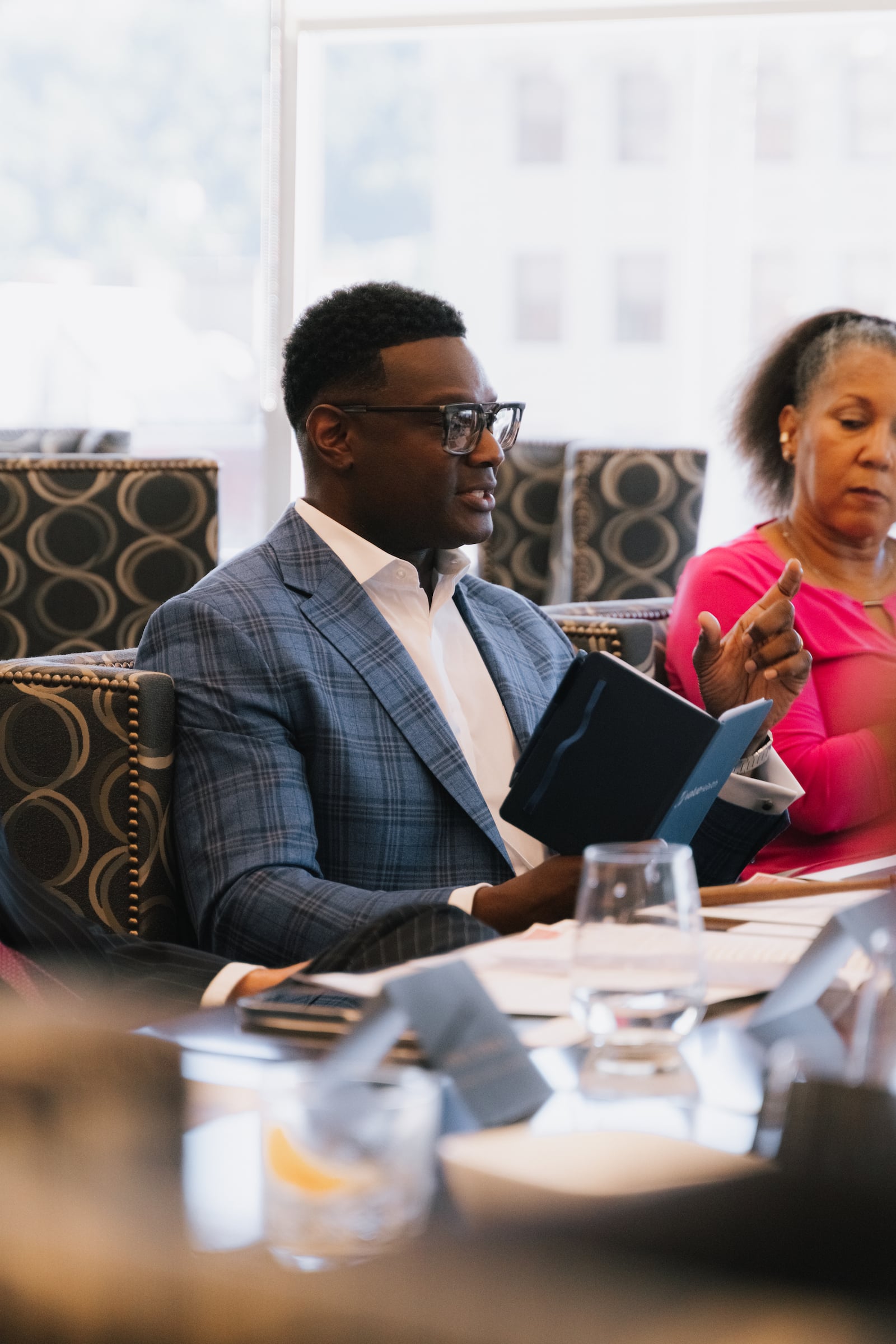 Man seated at a meeting looking at a program