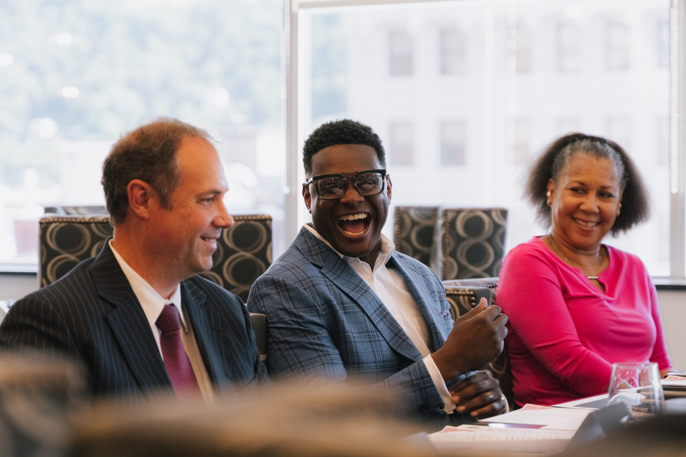 Two men & a woman seated at a meeting