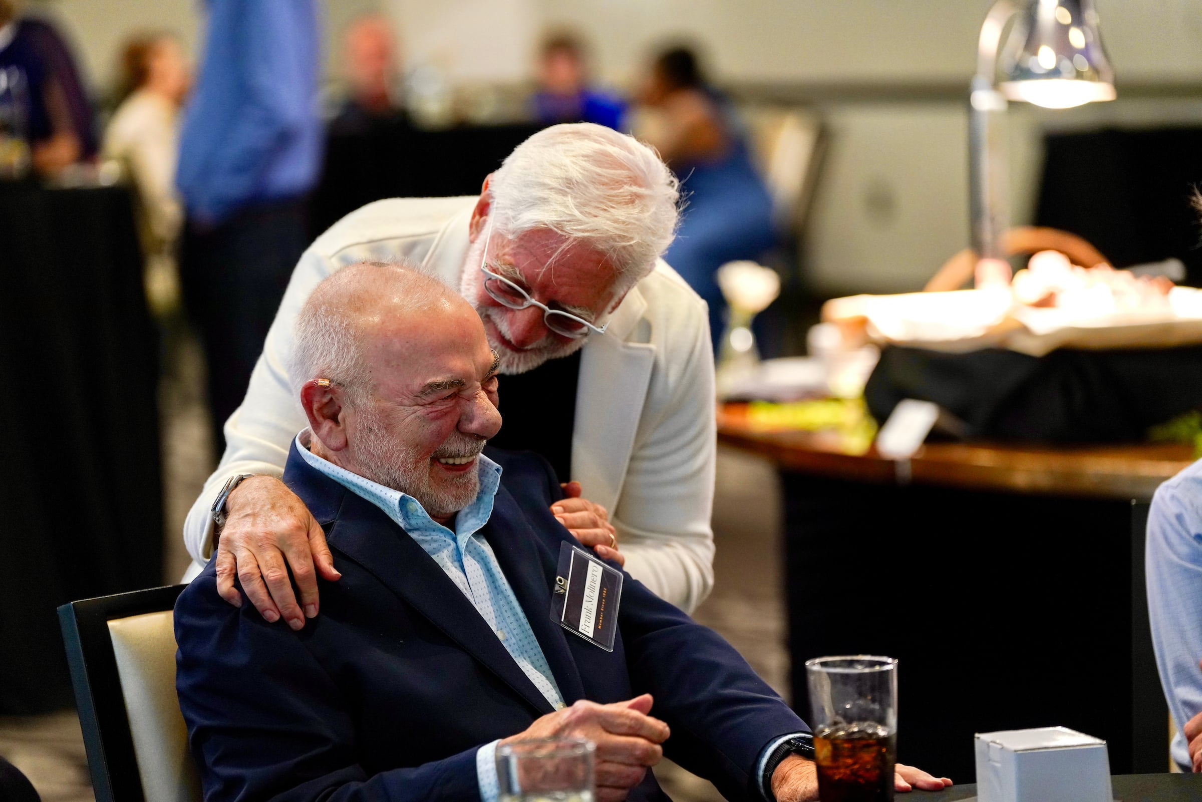 Two elderly men laughing at a private event