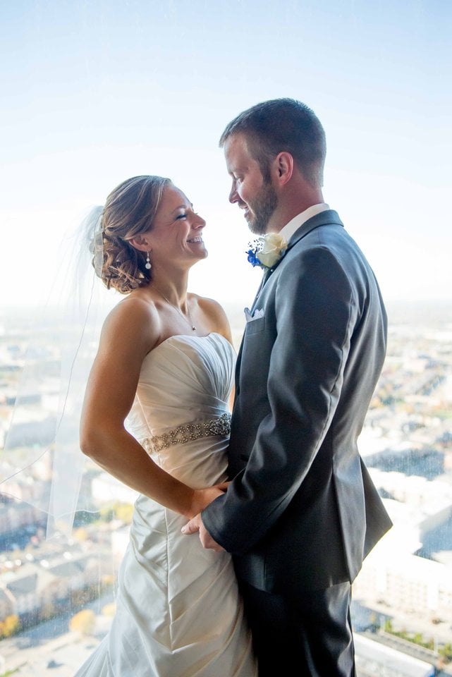 Bride & Groom standing in front of a window