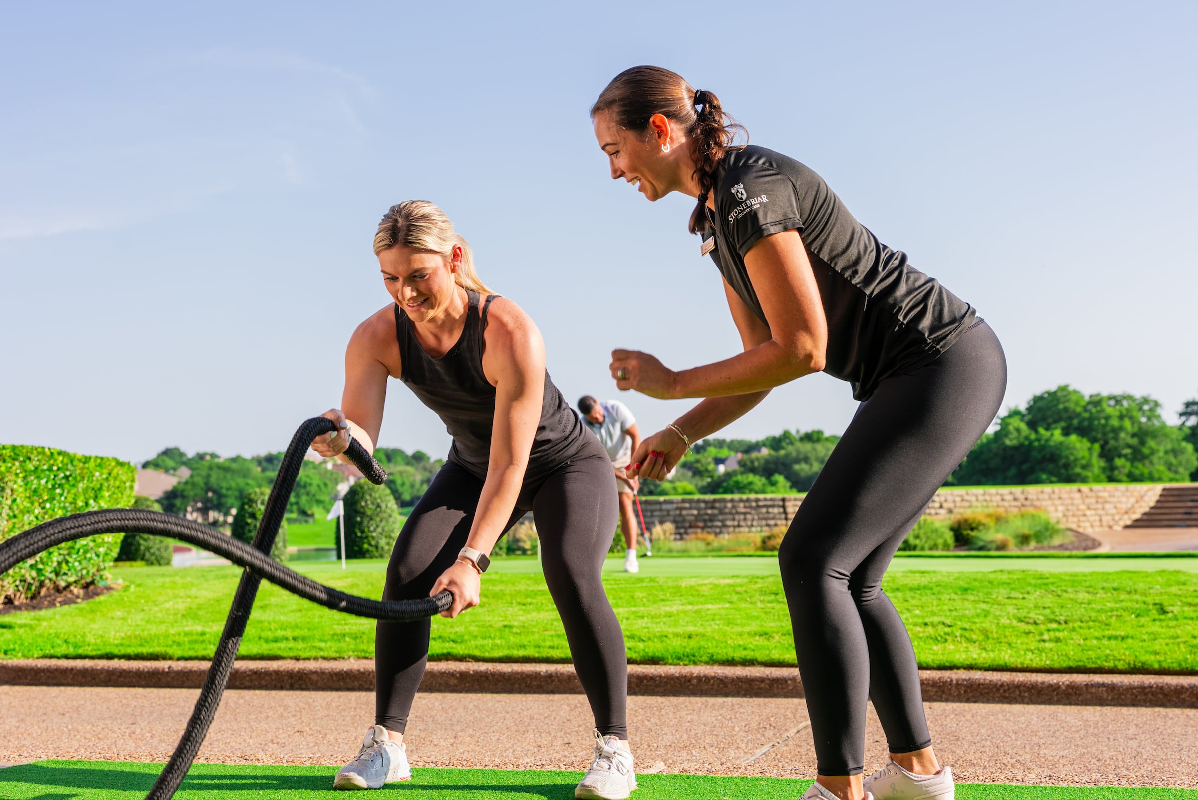 Young lady and trainer doing a workout together outside