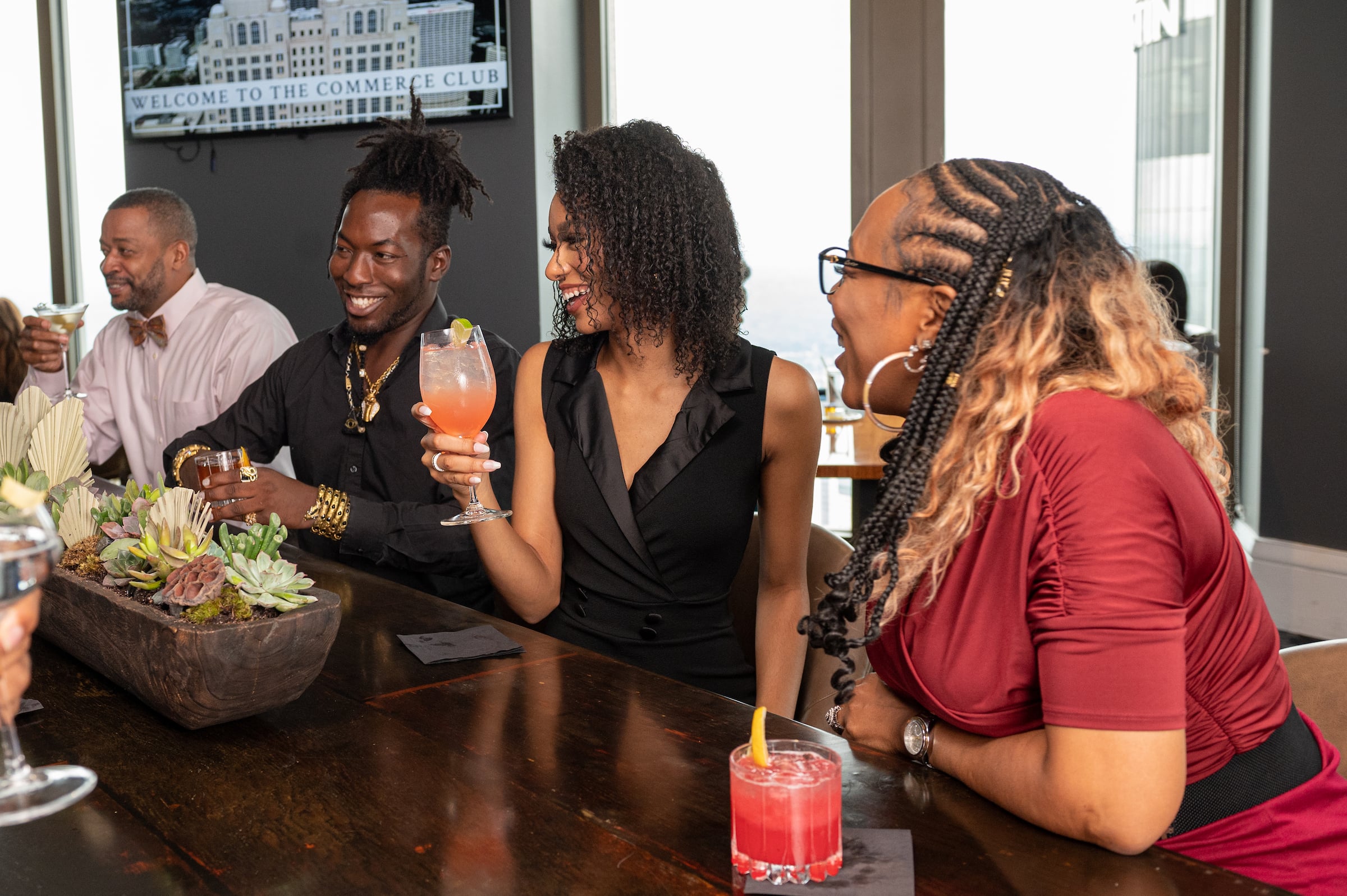 Two women & two men drinking at the bar
