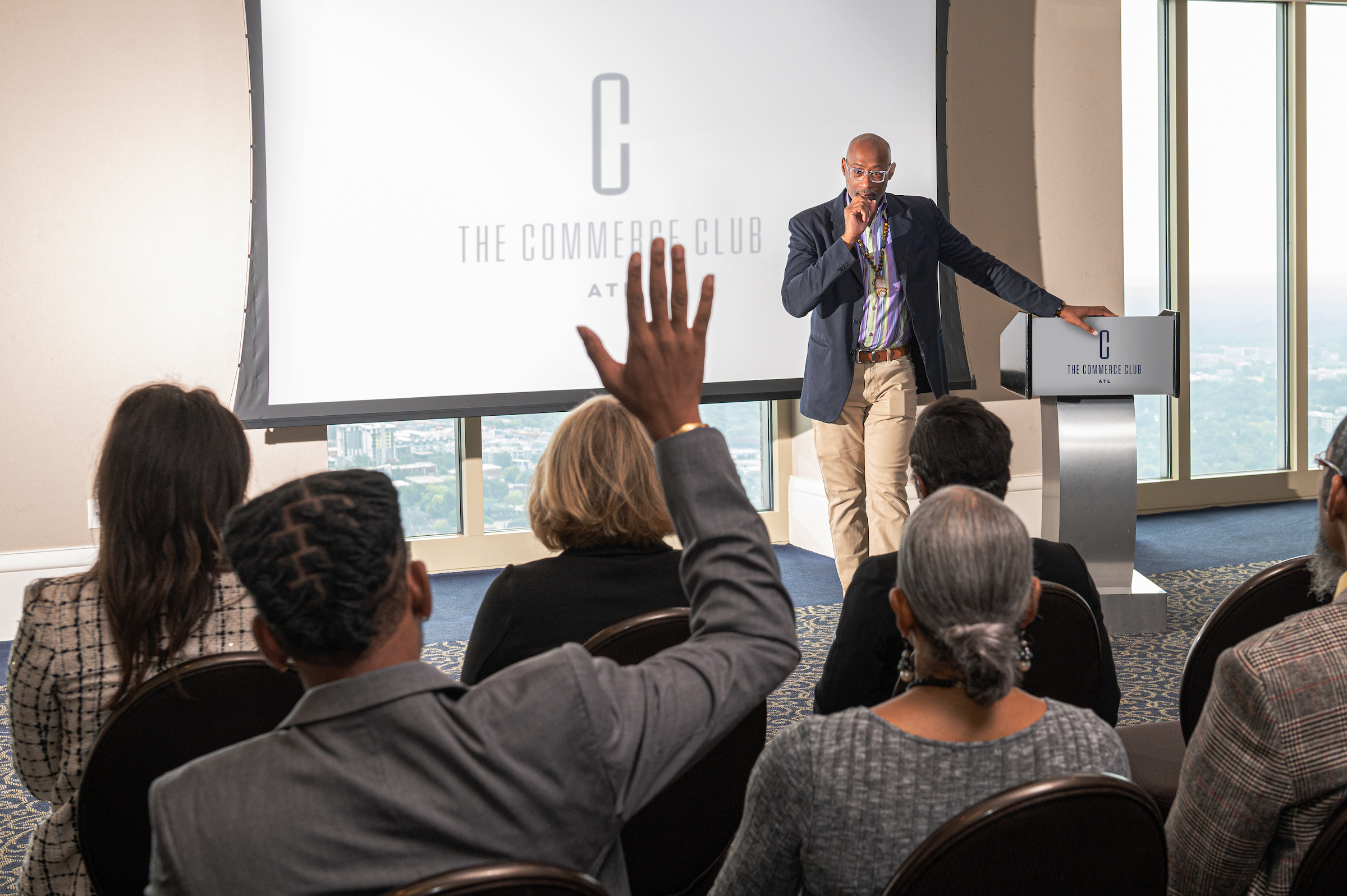 Male speaker at a podium speaking to a large group
