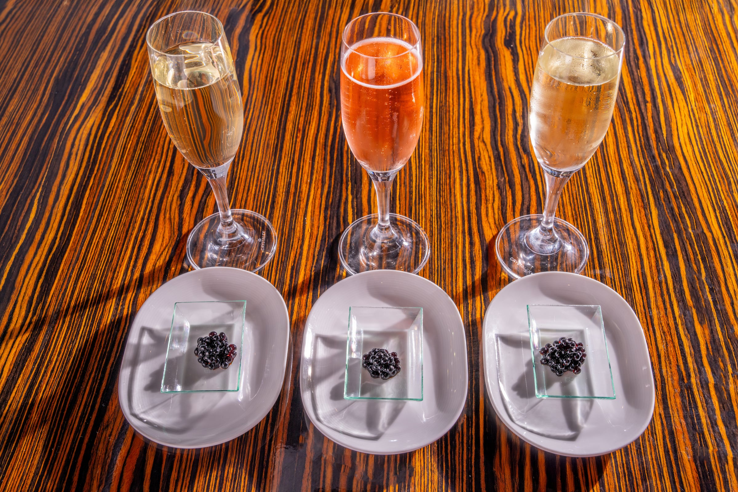 Three champagne glasses & 3 plates of caviar