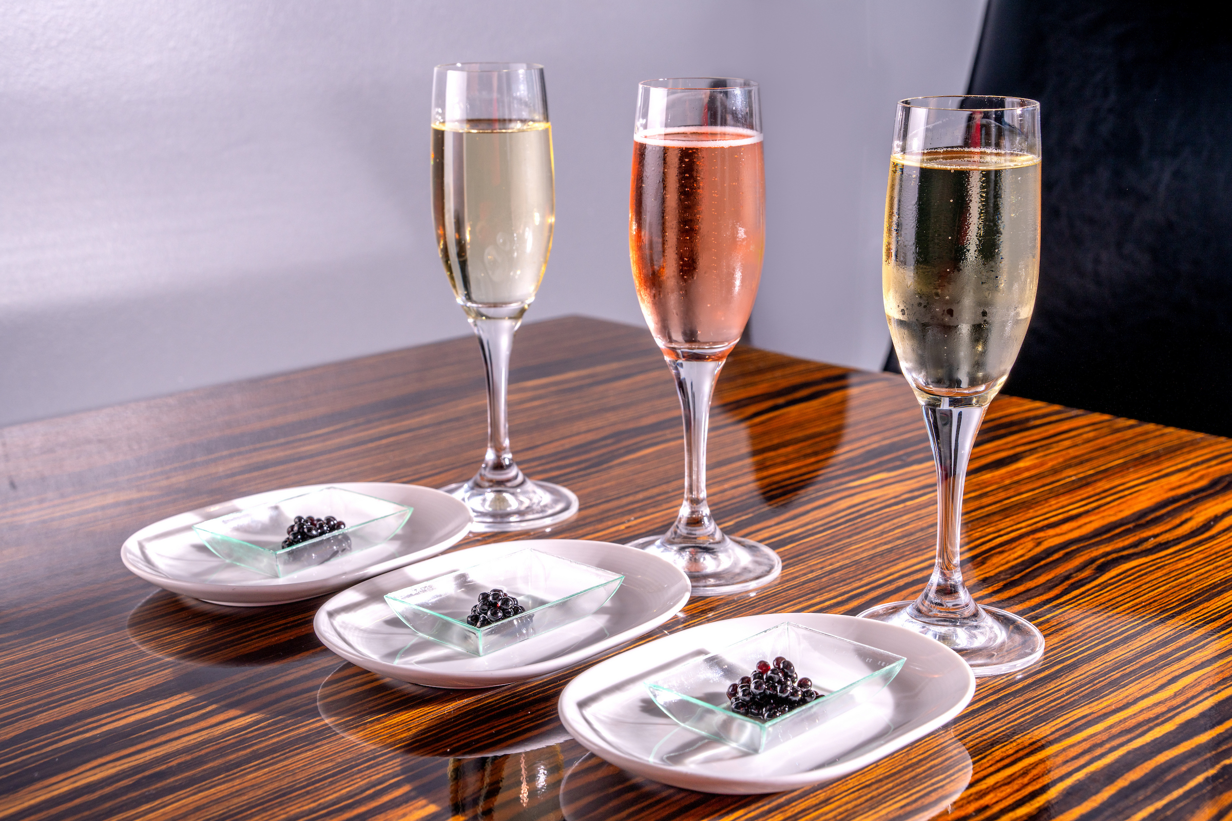 Three glasses of champagne & 3 plates of caviar