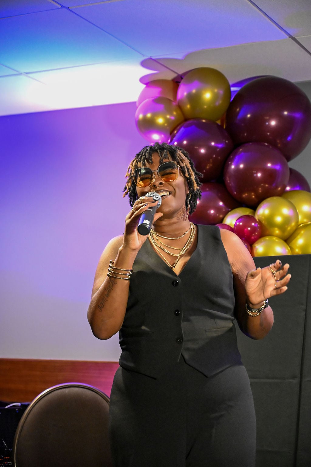 Woman speaking with a mic at a Private event celebrating women