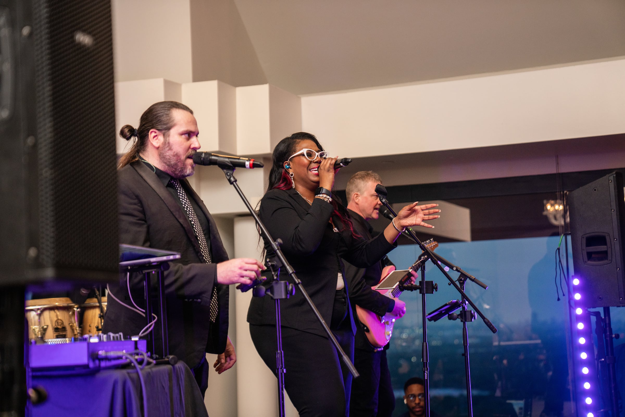 One woman & two men singing on stage