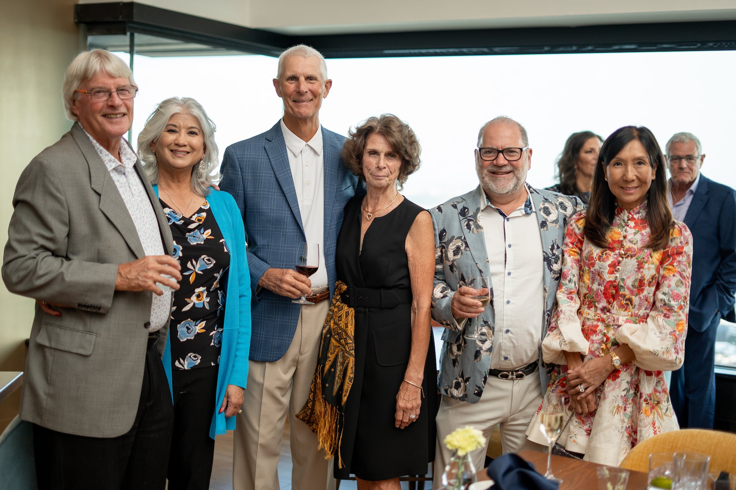 Three couples posing for a picture at a private event