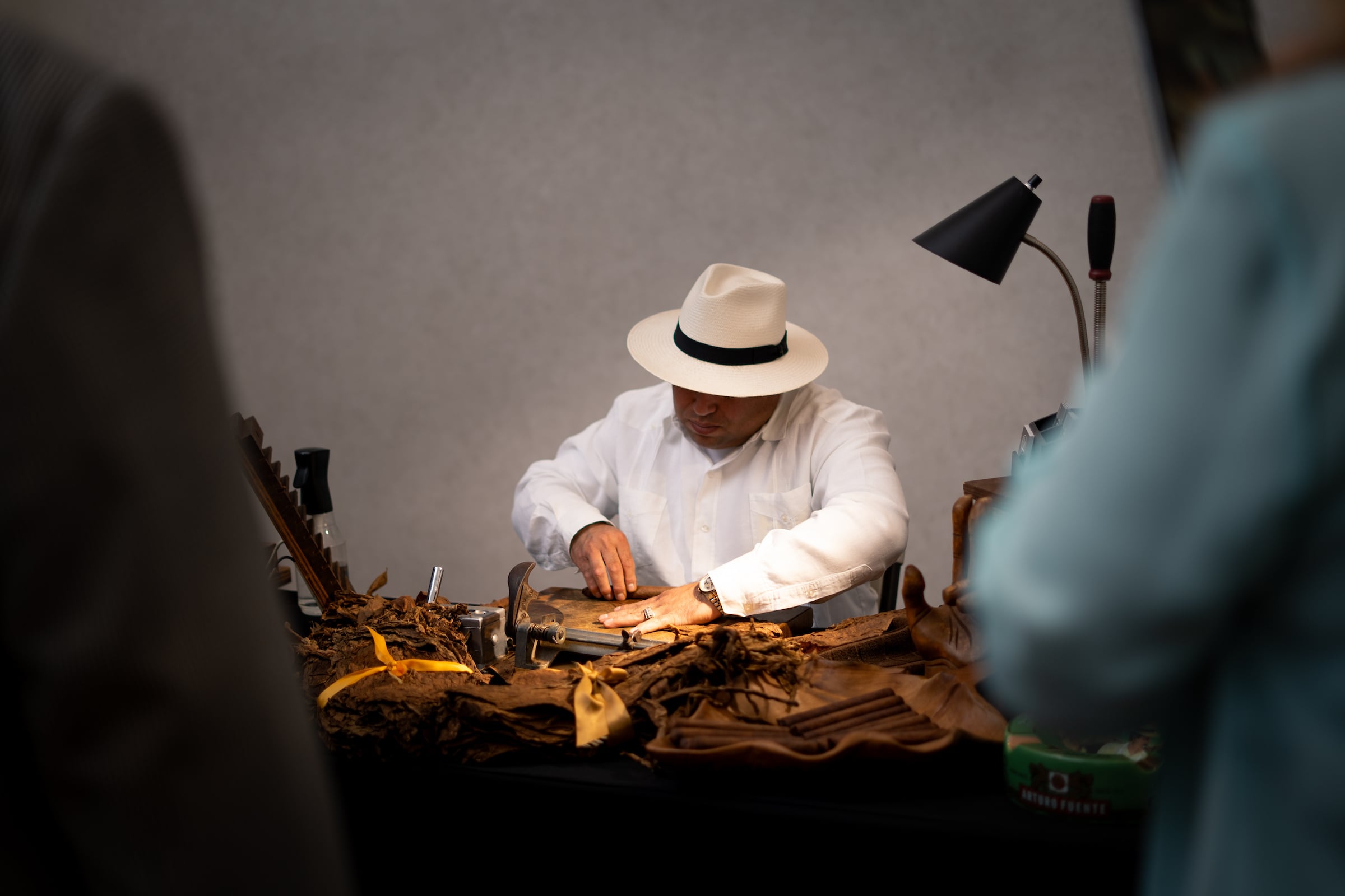 Man dressed in white with a white hat working at a table at a private event
