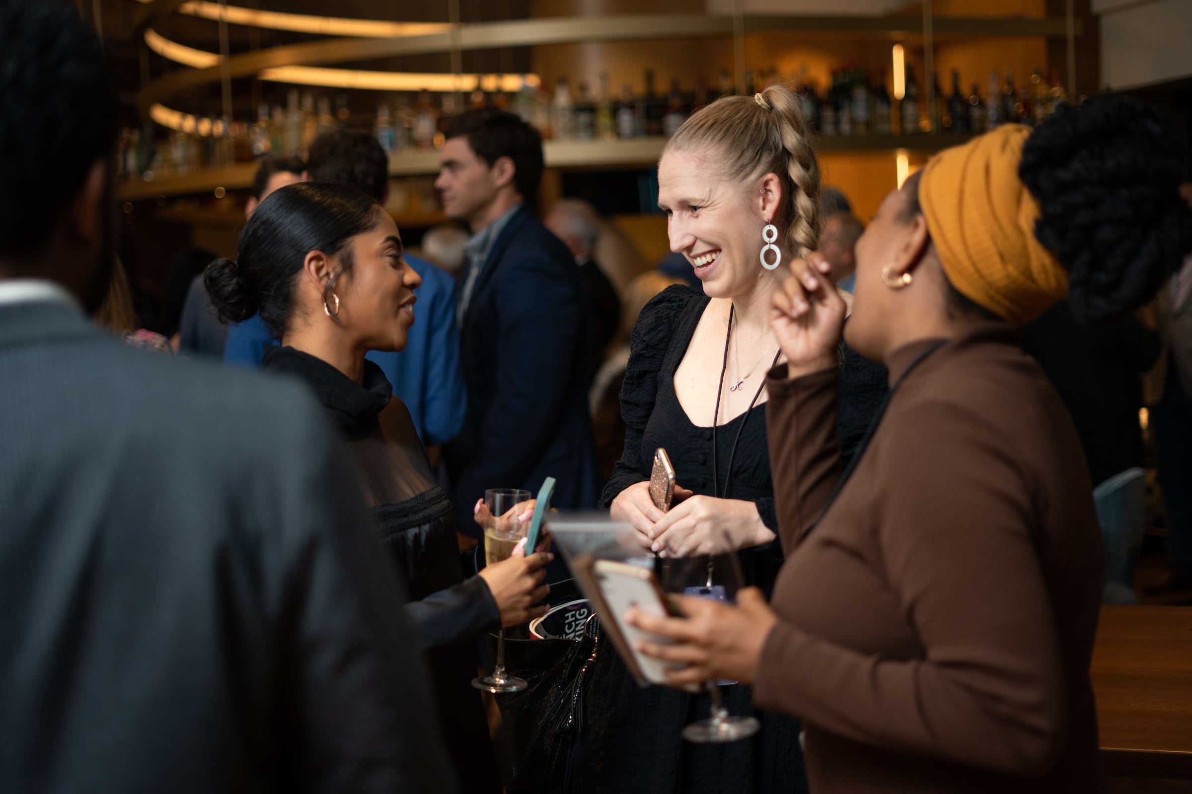 three women drinking, talking & laughing at a private event