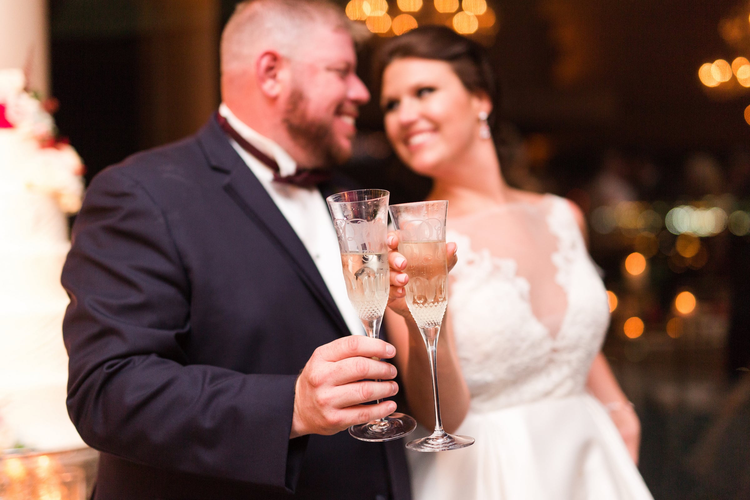 Bride & Groom smiling and holding out champagne glasses